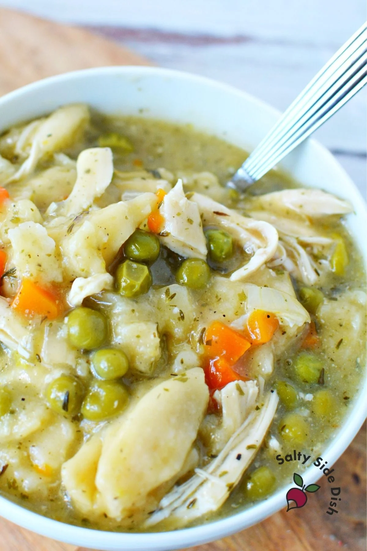 peas and carrots in bowl of chicken and dumplings.