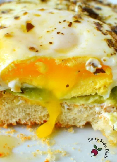 runny eggs on a sandwich with pesto and avocado.