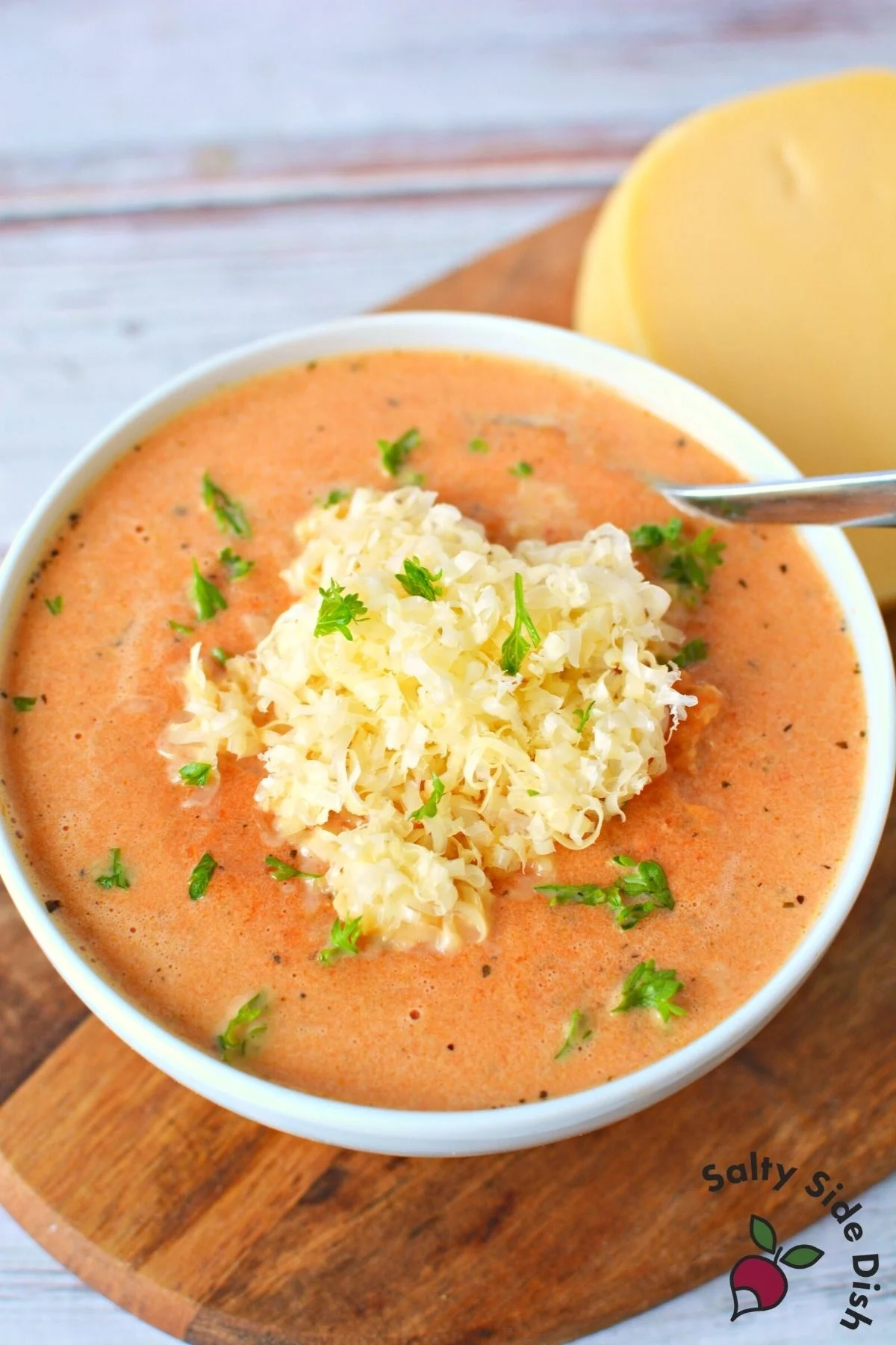 red pepper gouda soup in a white bowl.