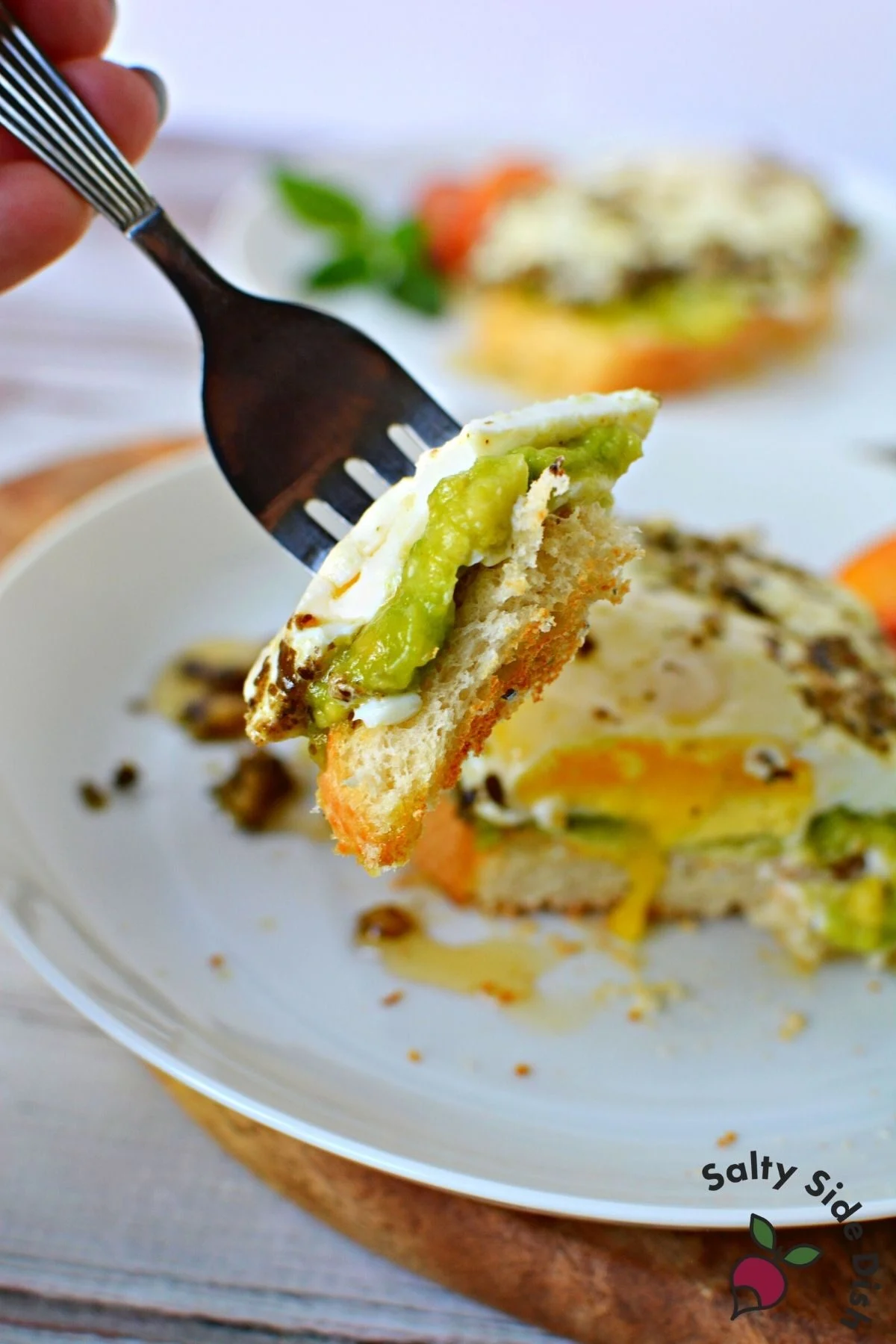 fork with pesto eggs and toast on it.