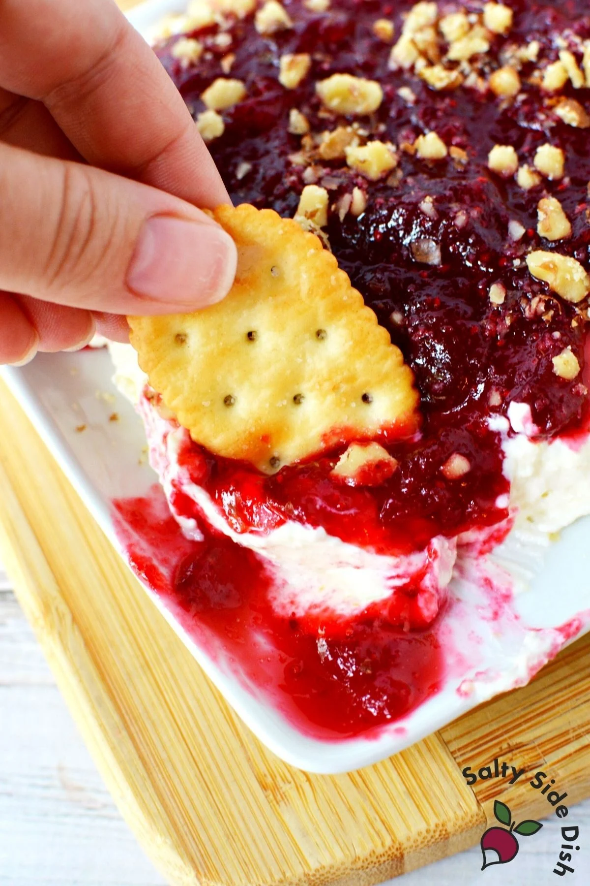 dipping cracker into whipped feta dip.