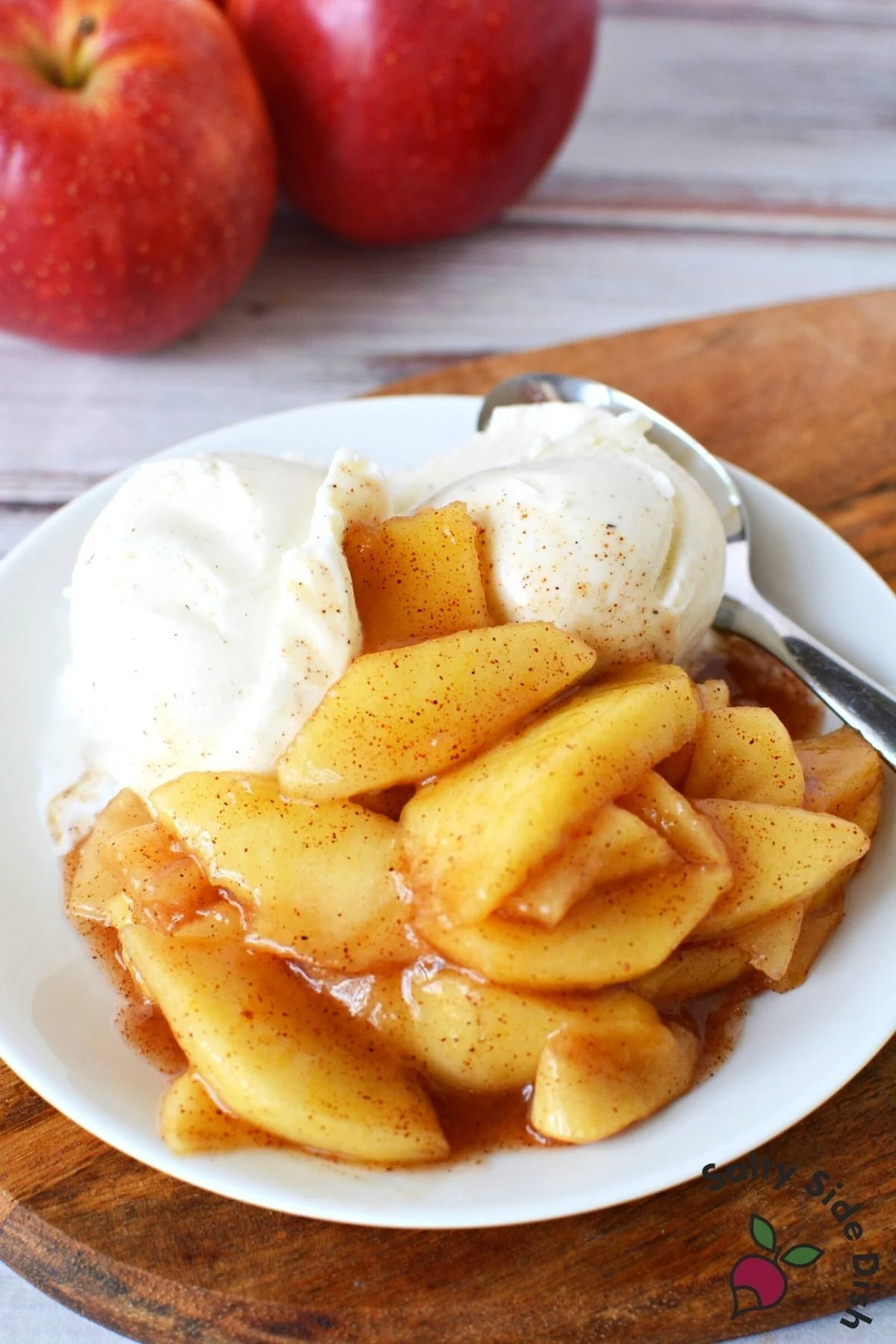 white plate with apple pie filling and ice cream.