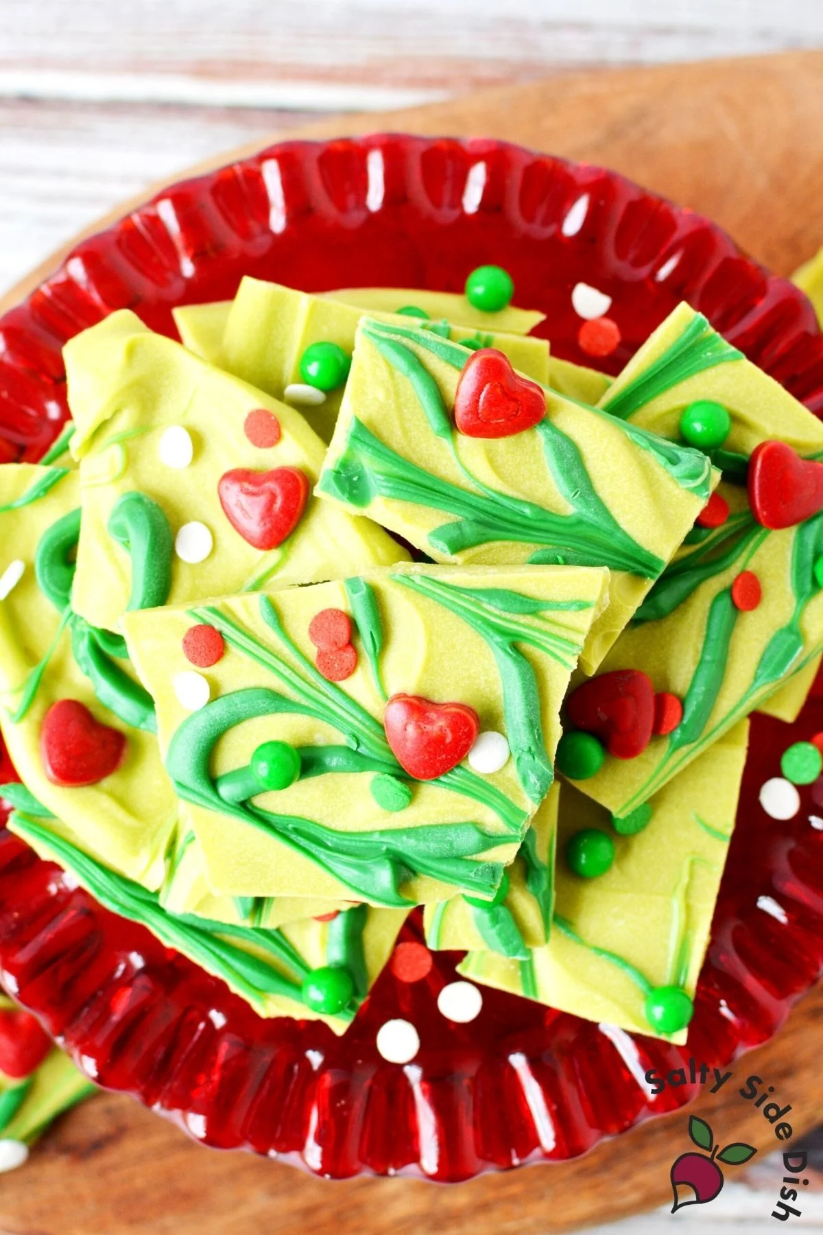 pile of green candy bark with grinch colors on a red plate.