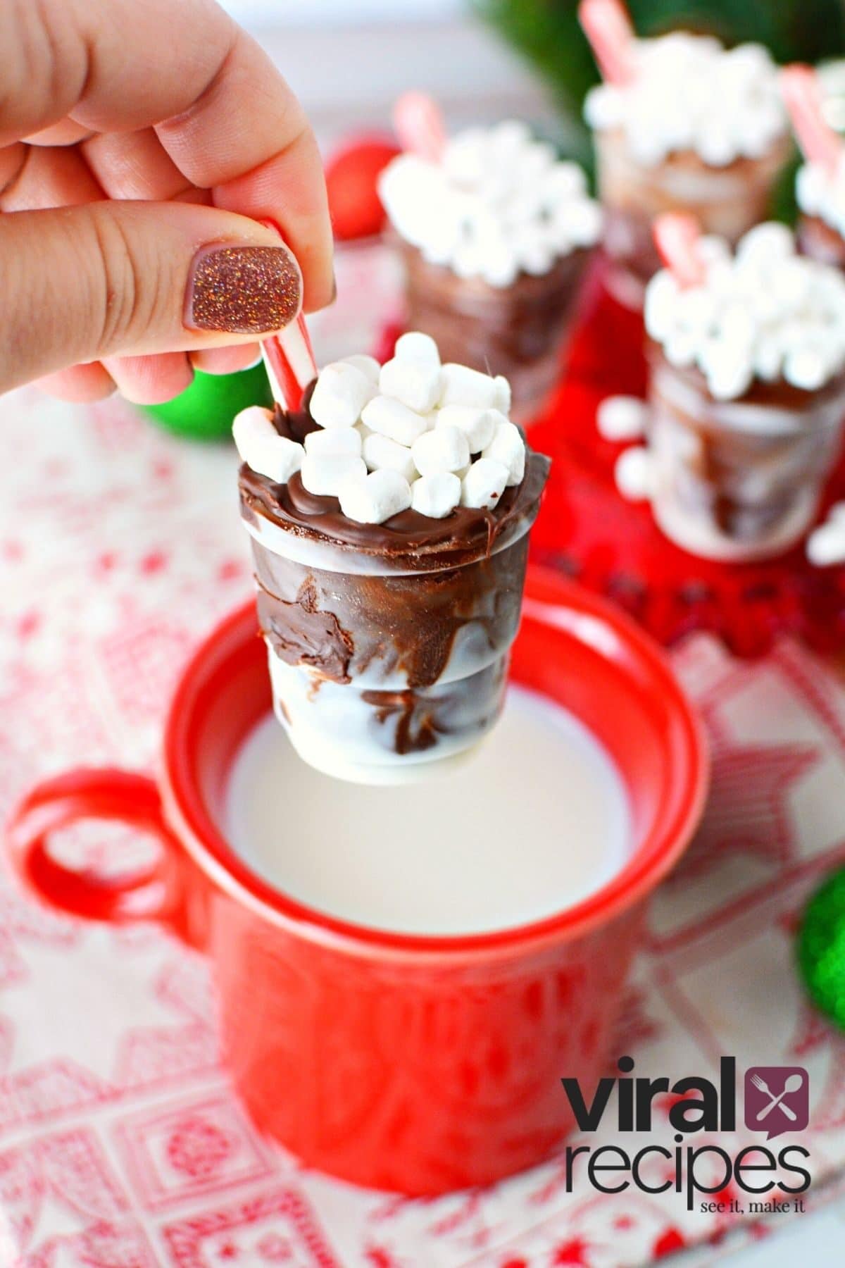 dipping solo cup chocolate cups into warm milk.