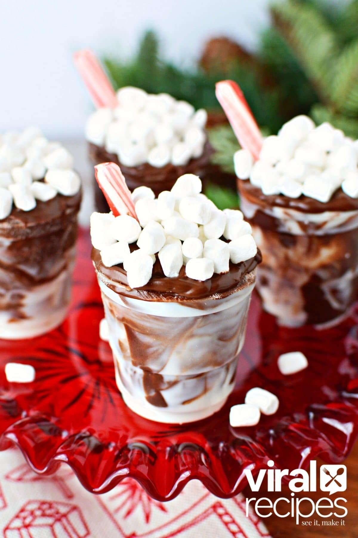 cocoa bomb cups on a red plate with marshmallow bits.