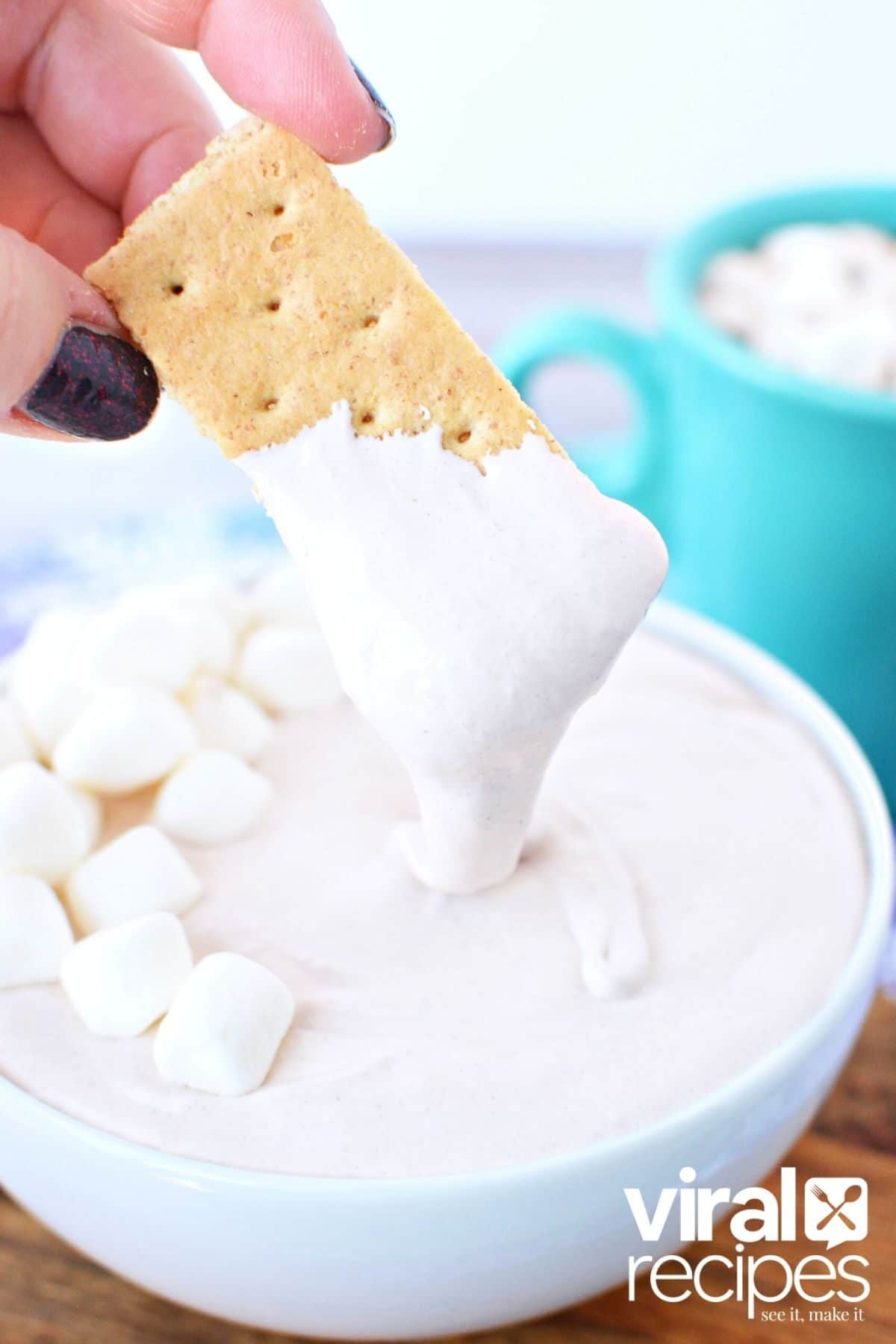 tiktok hot cocoa dip being dipped with graham cracker.
