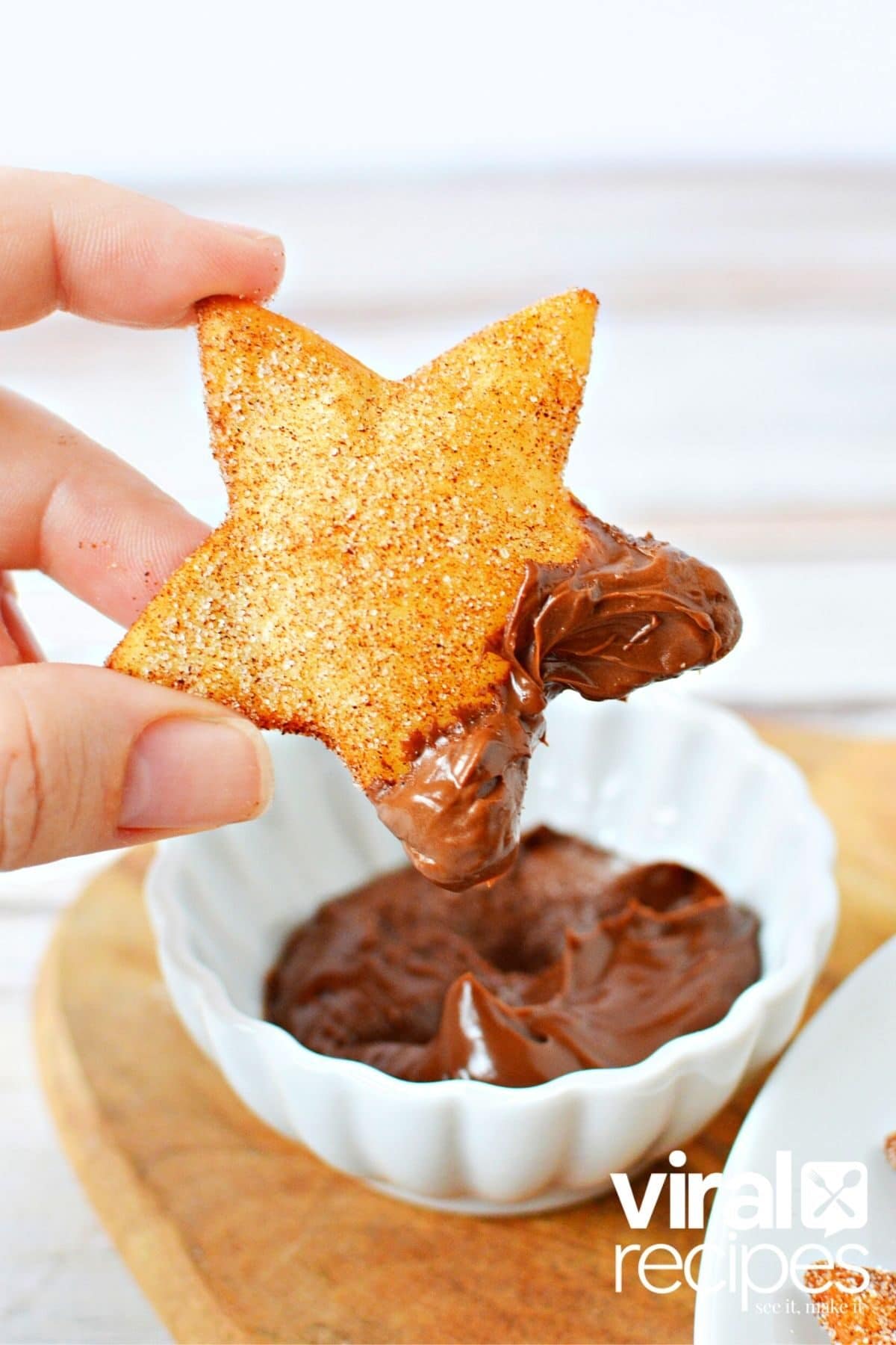 holding a star shaped churro nacho dipped in Nutella.