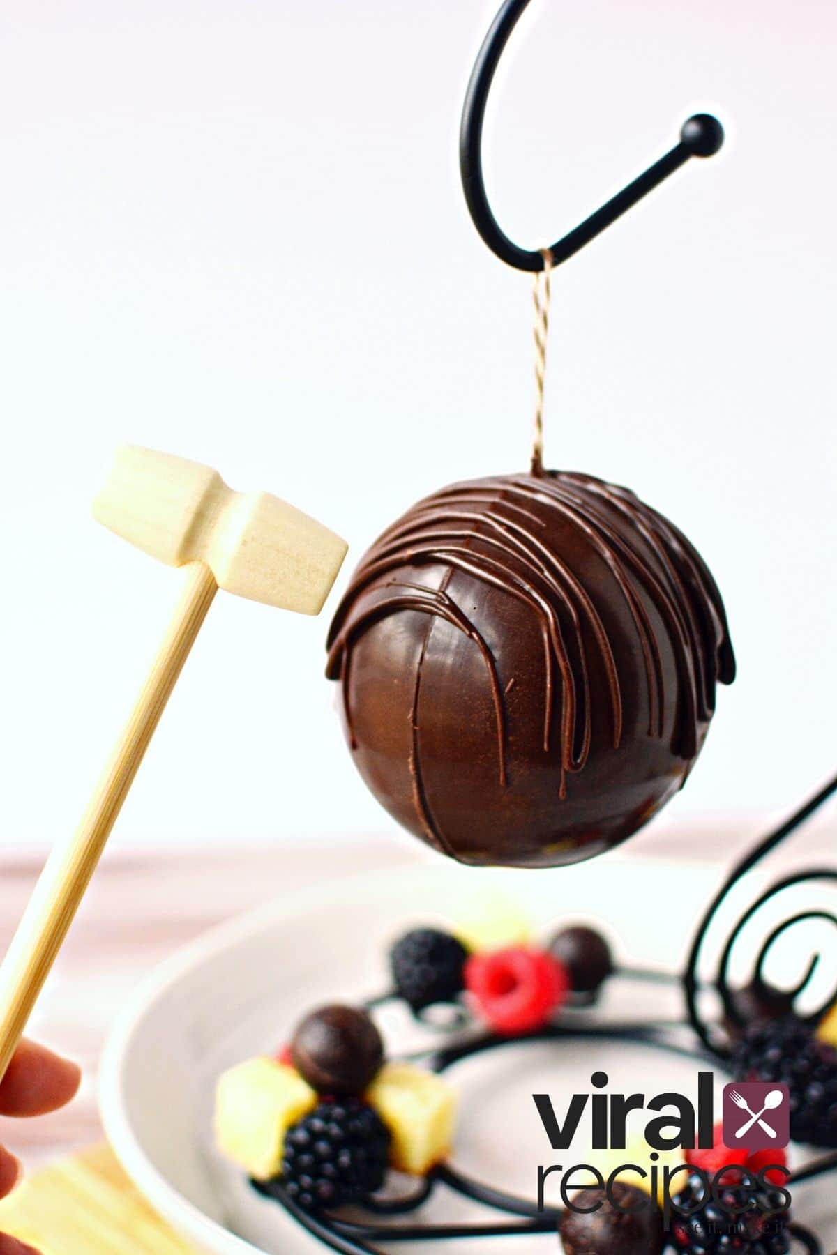 hitting tiny wooden mallet on chocolate piñata.