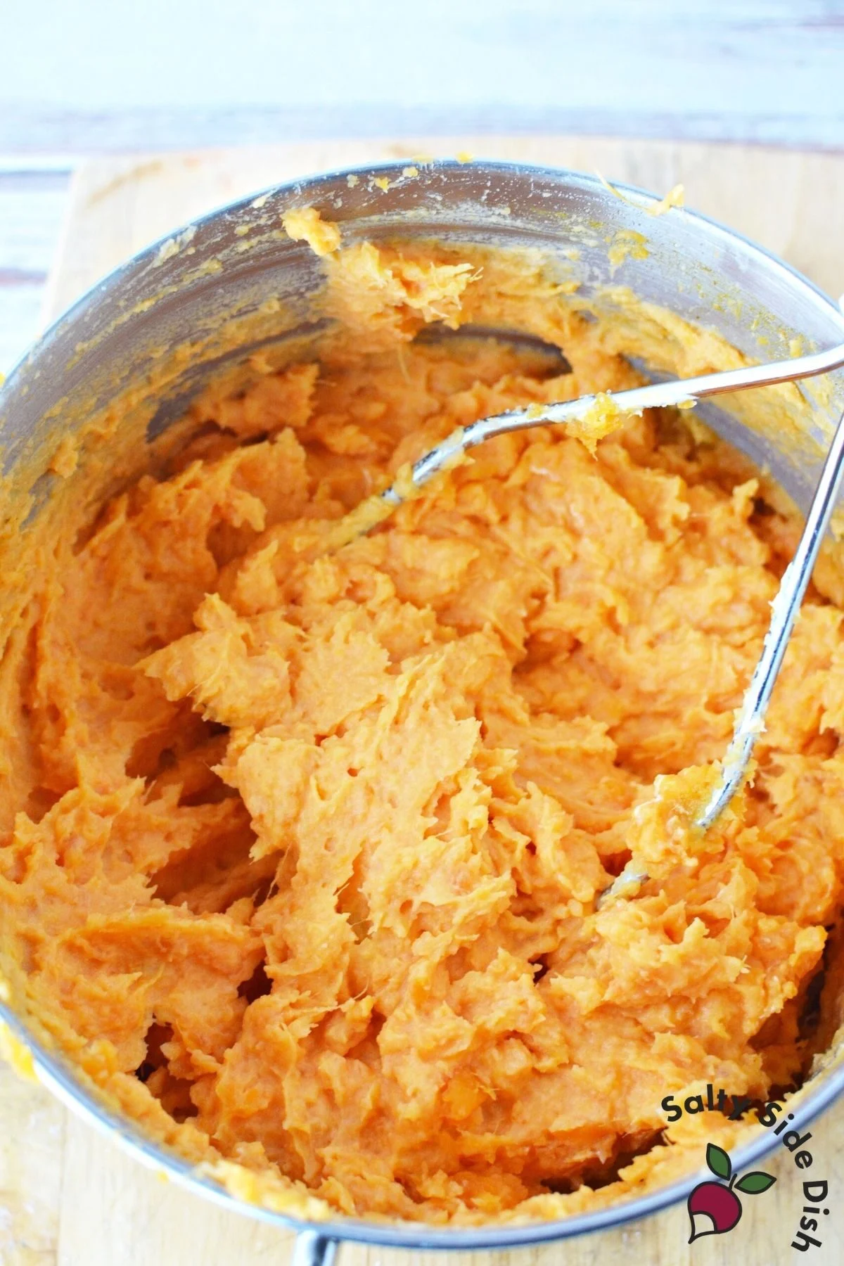 mashing potatoes with a manual masher.