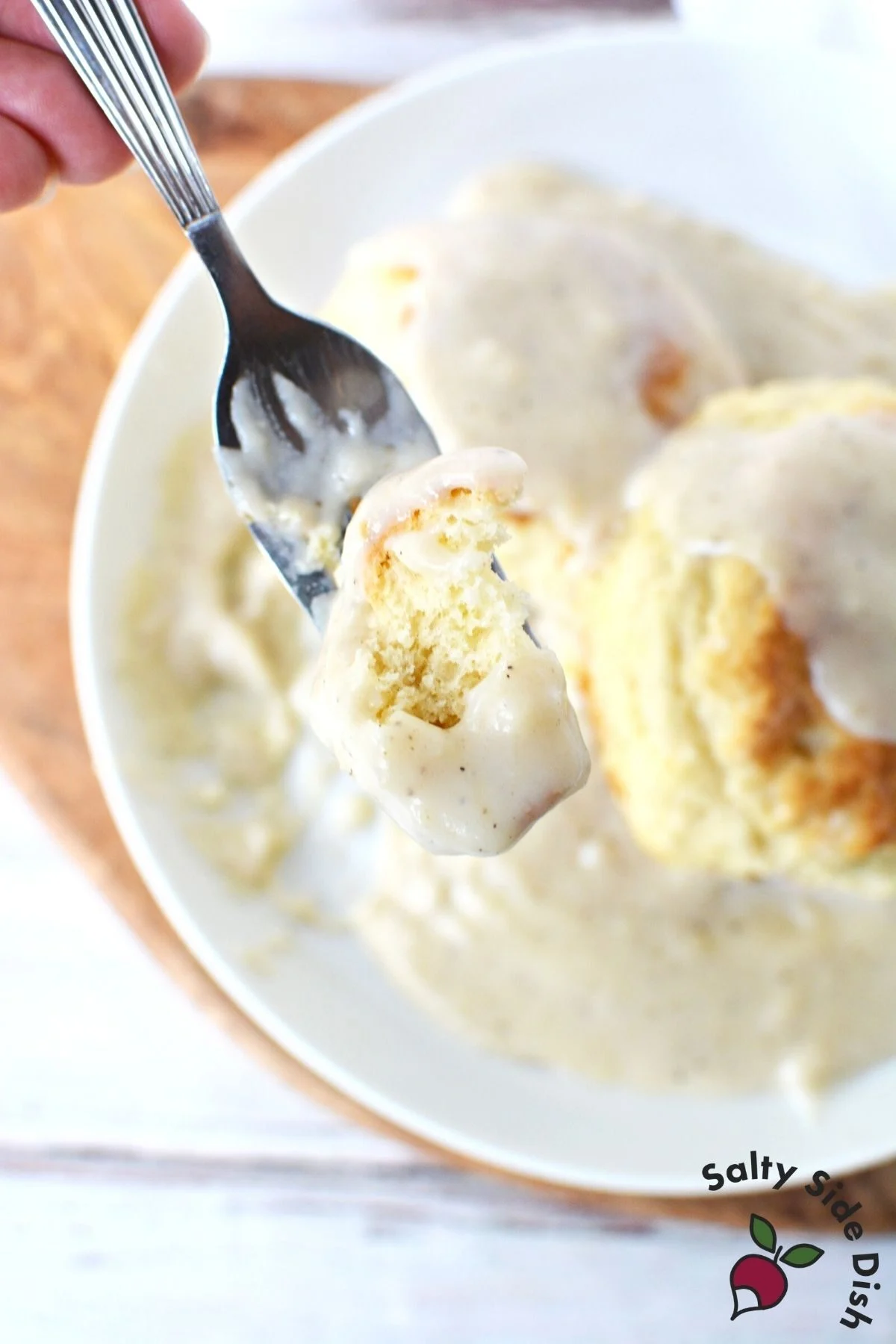 fork holding biscuit n gravy.