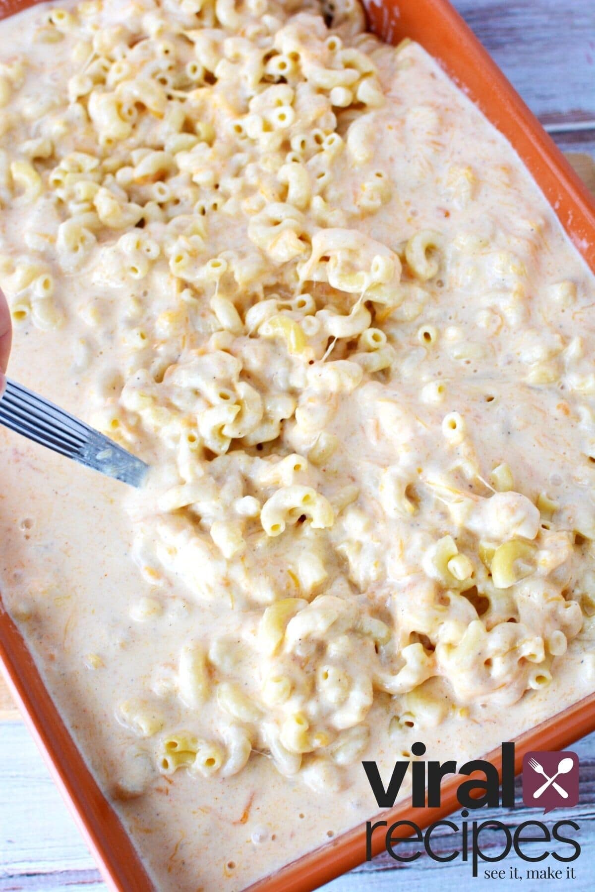 combining cheese sauce and noodles for mac and cheese recipe.