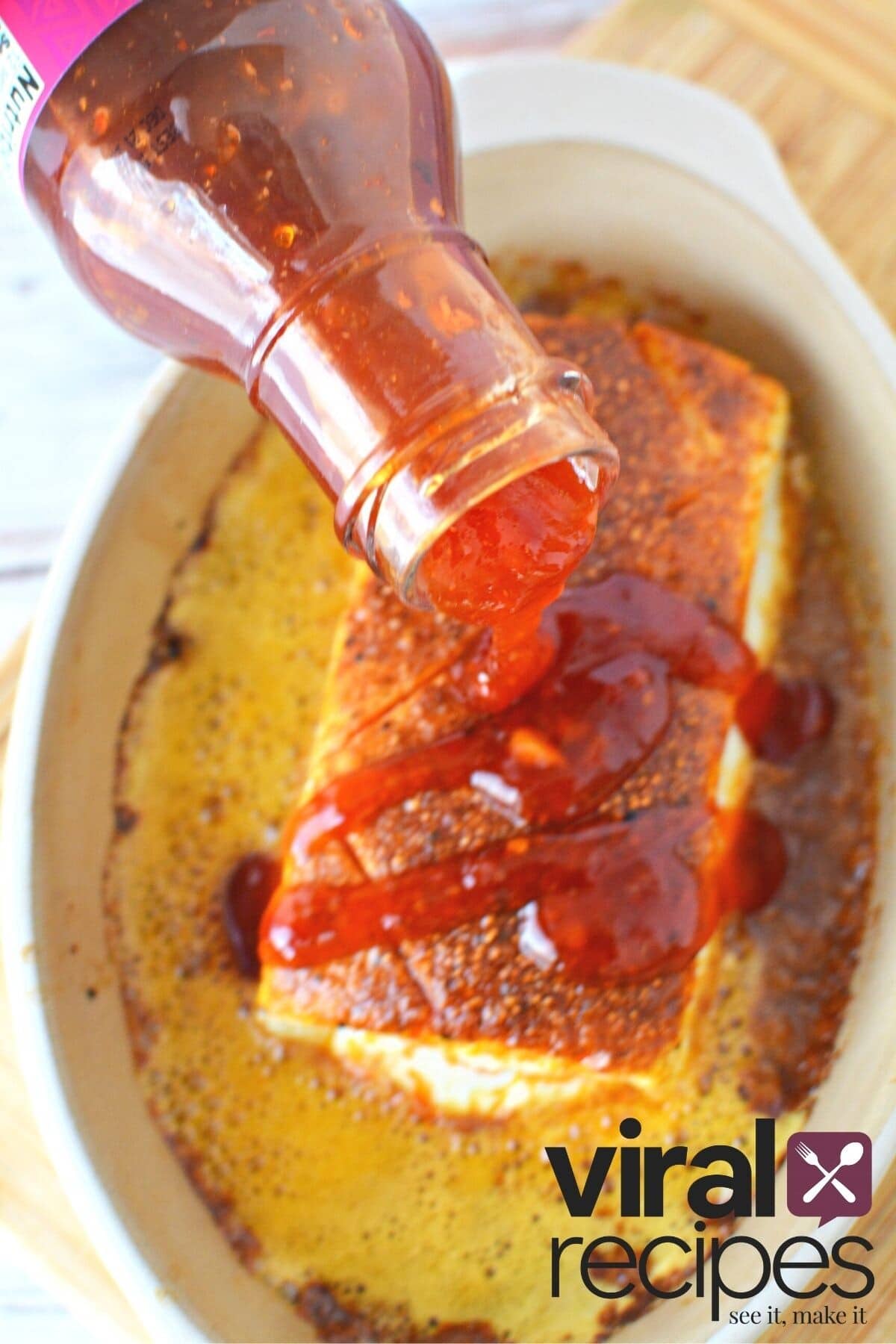 pouring chili sauce on smoked cream cheese.