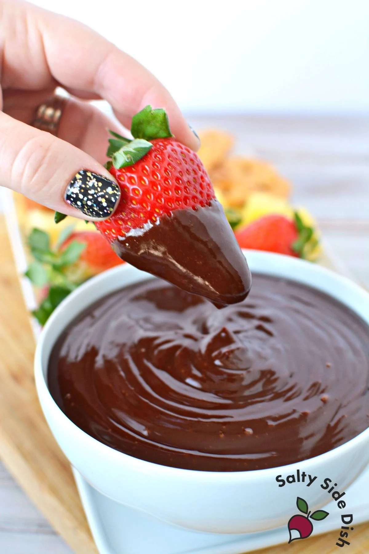 dipping strawberrie in chocolate ganache.