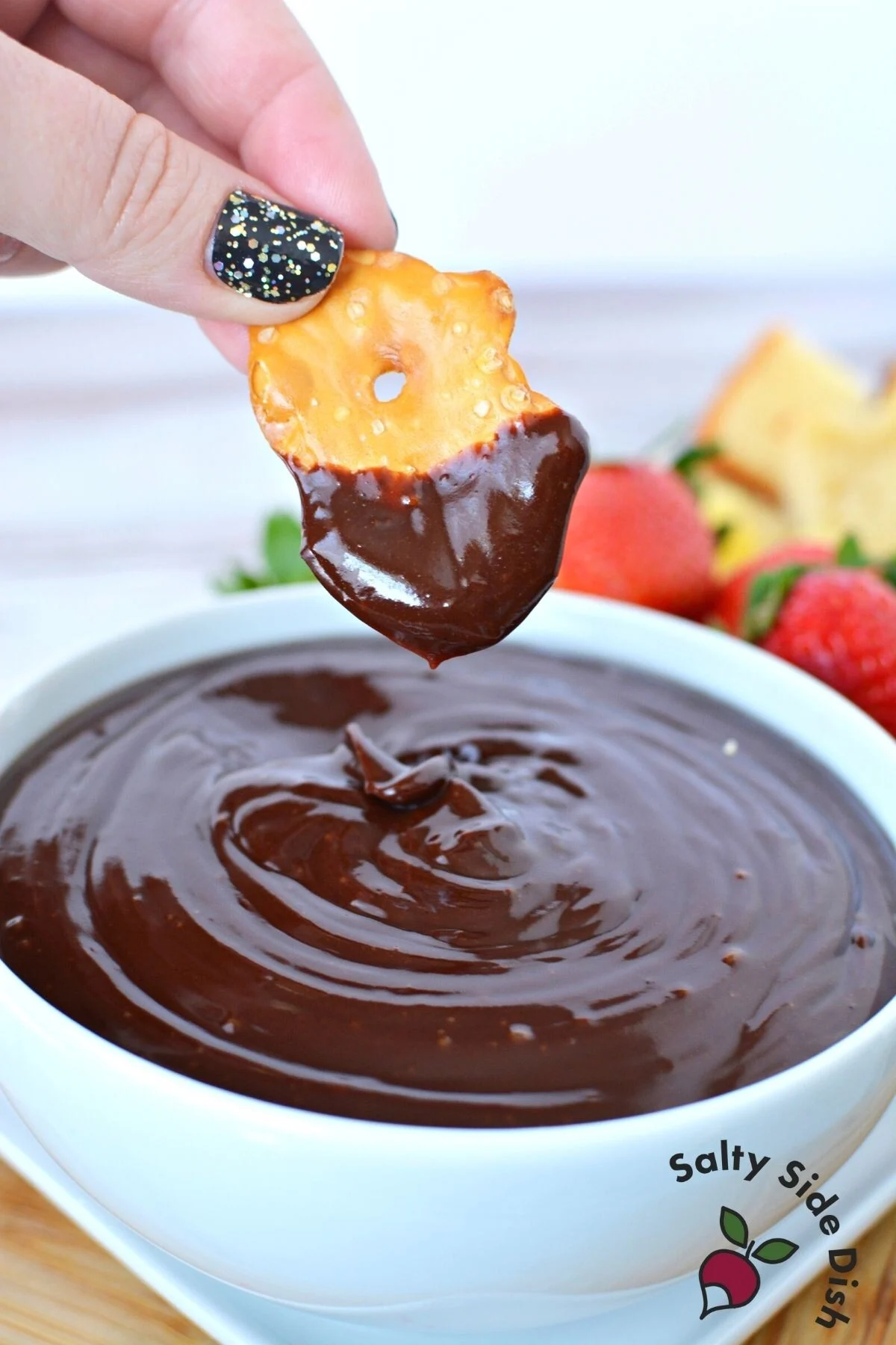 dipping pretzel into chocolate sauce.