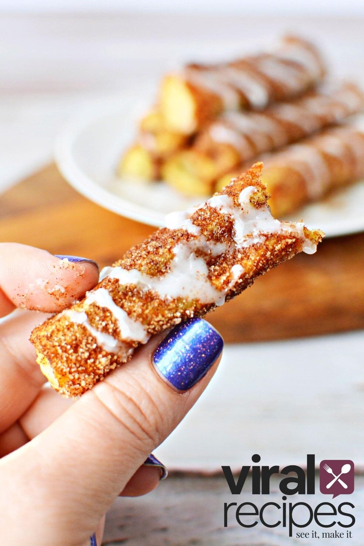 holding french toast sticks in between thumb and finger.
