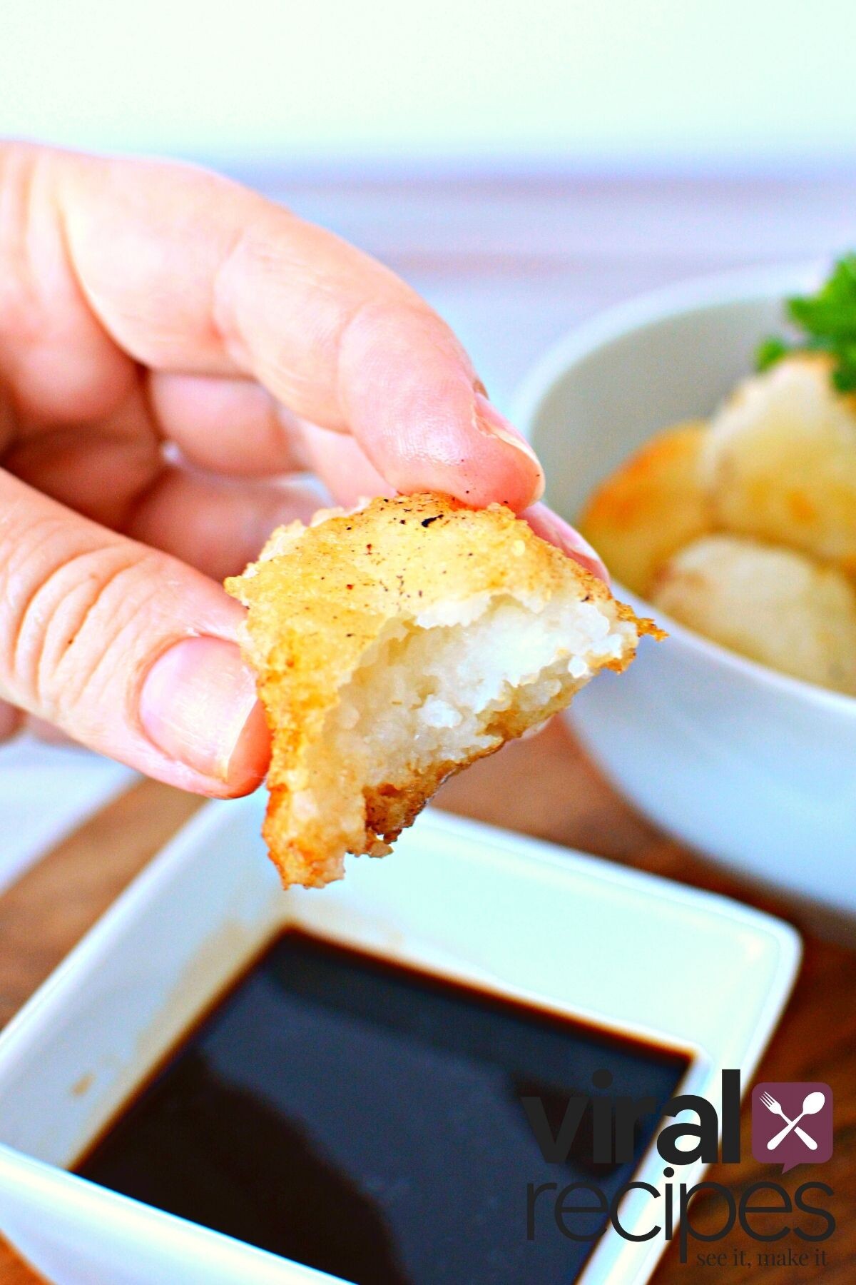 rice ball recipe being dipped into soy sauce.