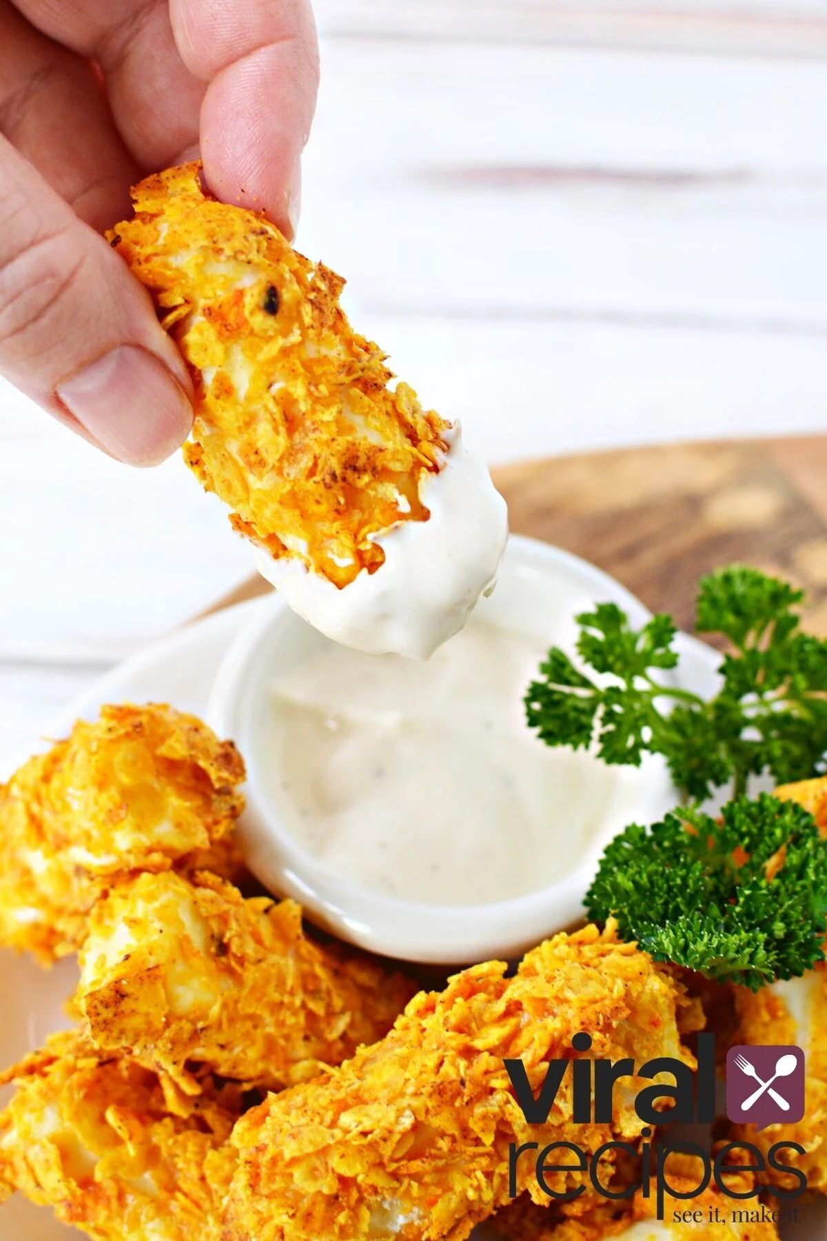 dipping doritos cheese stick into ranch dressing.