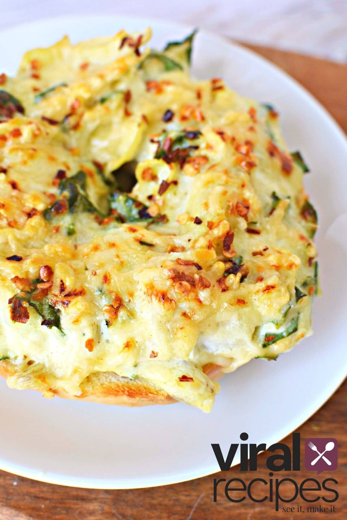 spinach dip piled high on a bagel.