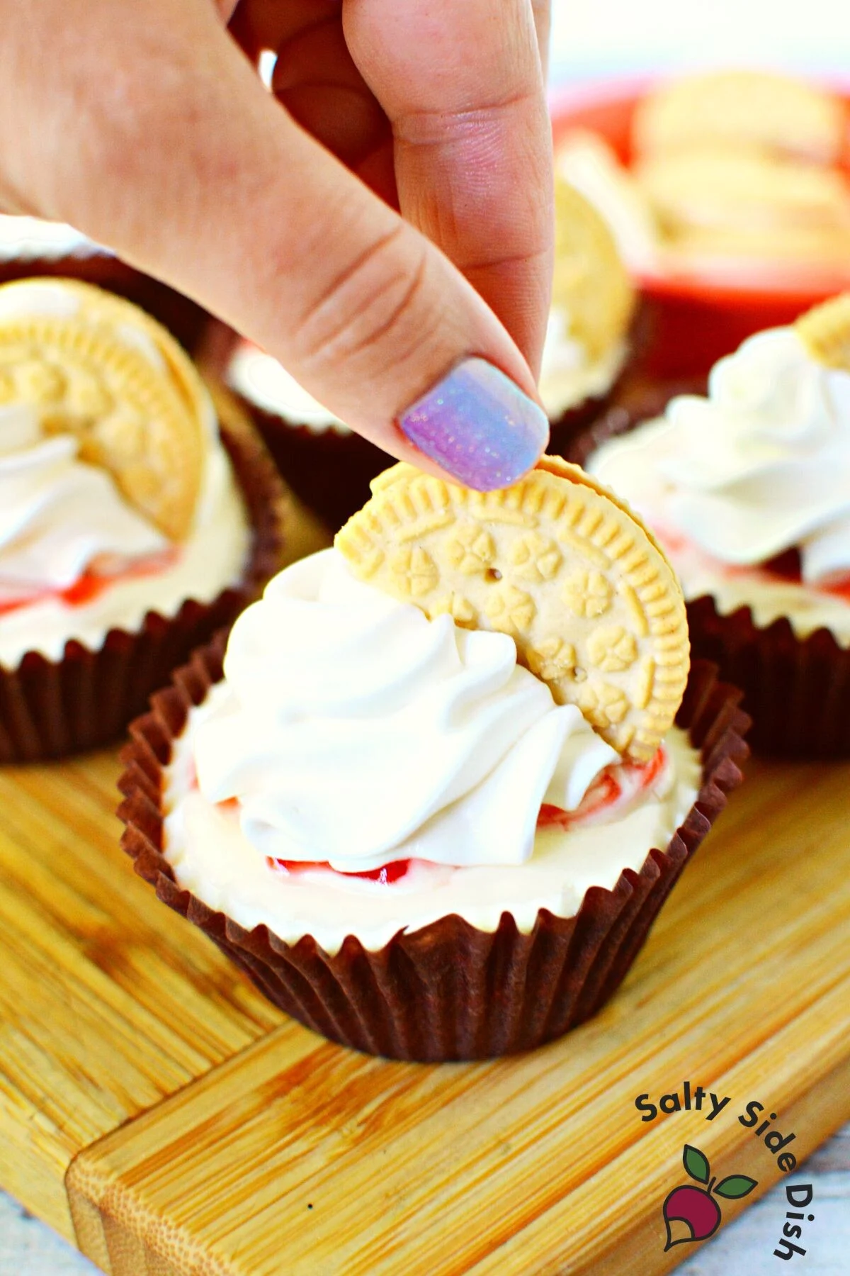 adding golden oreo to each cheesecake bite.