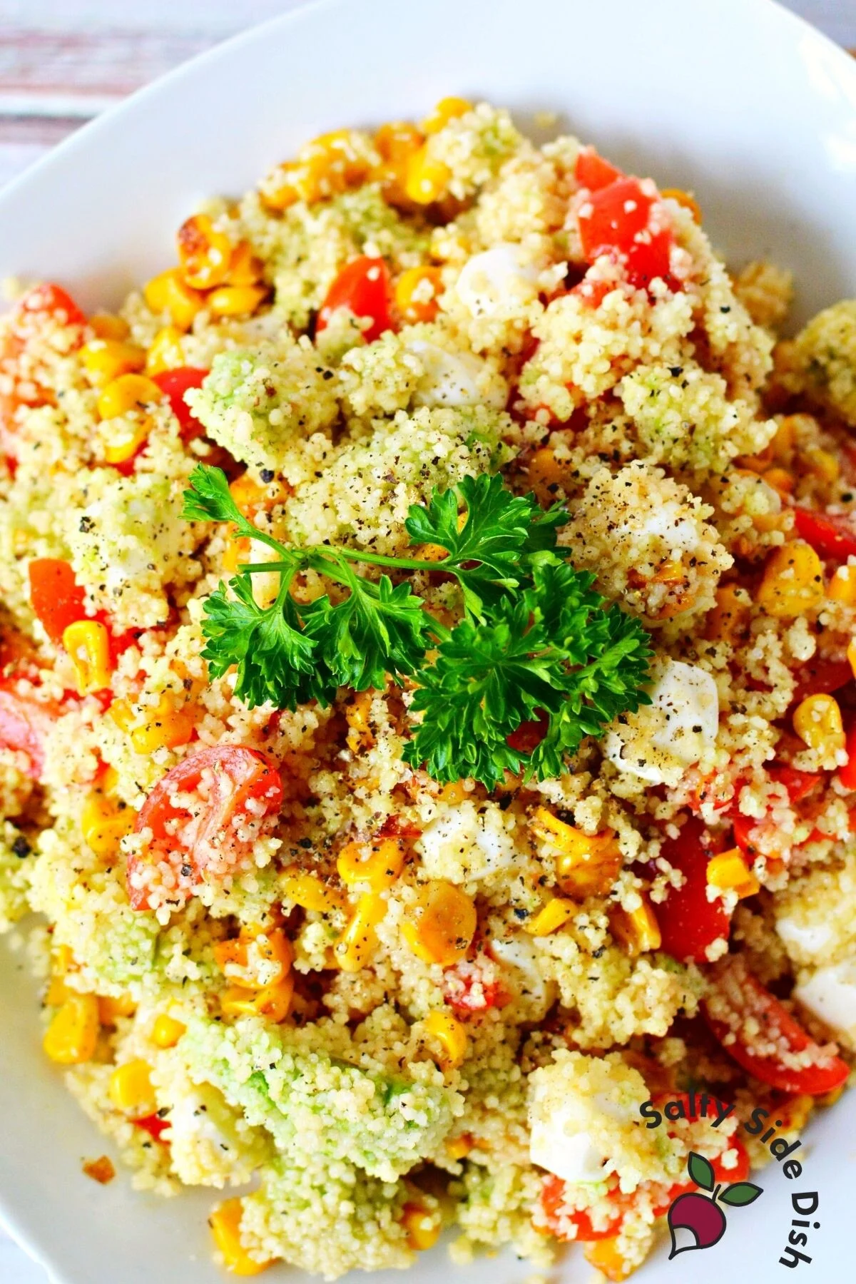 easy summer couscous salad on a white plate.