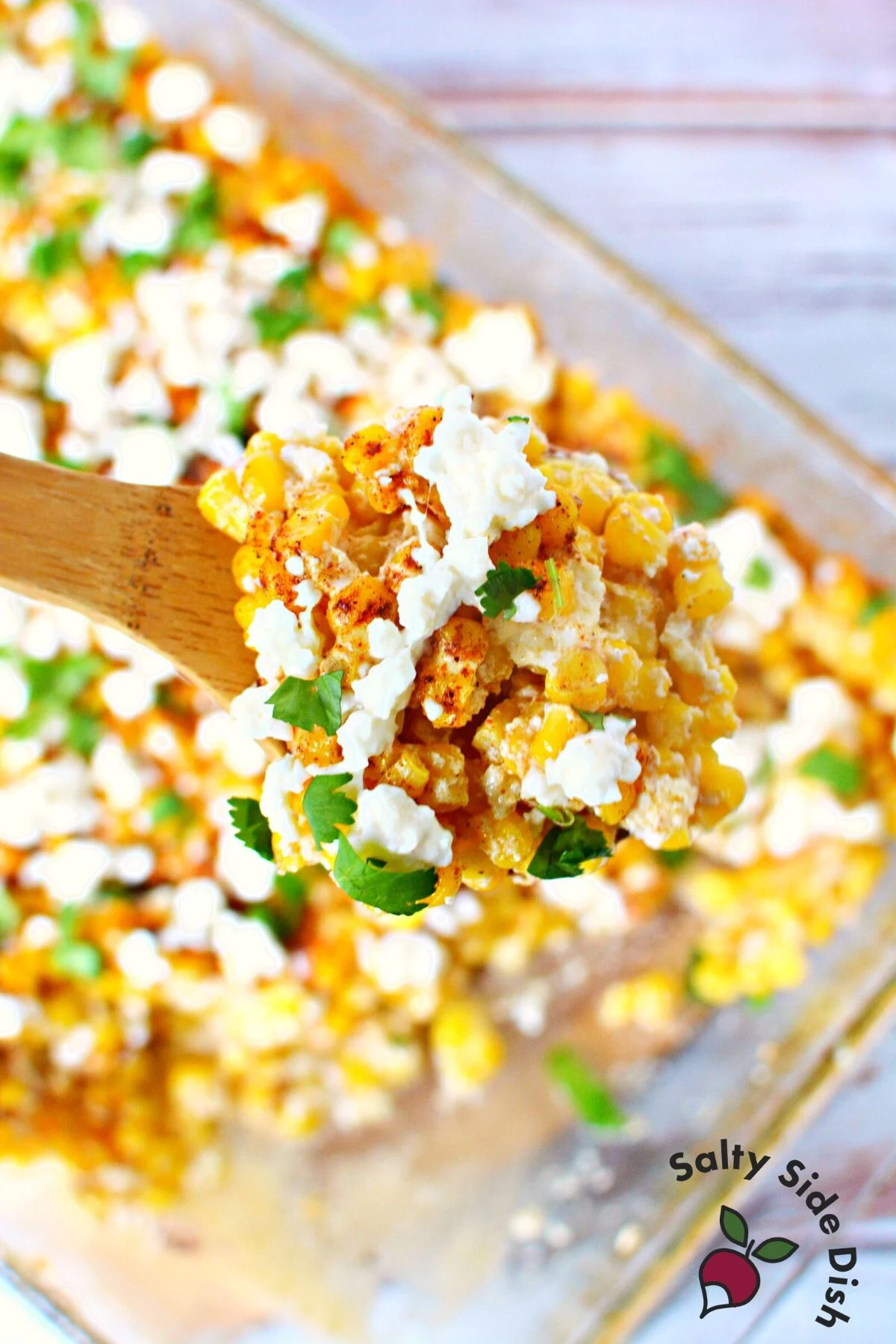 scoop of mexican street corn casserole recipe in a wooden spoon.