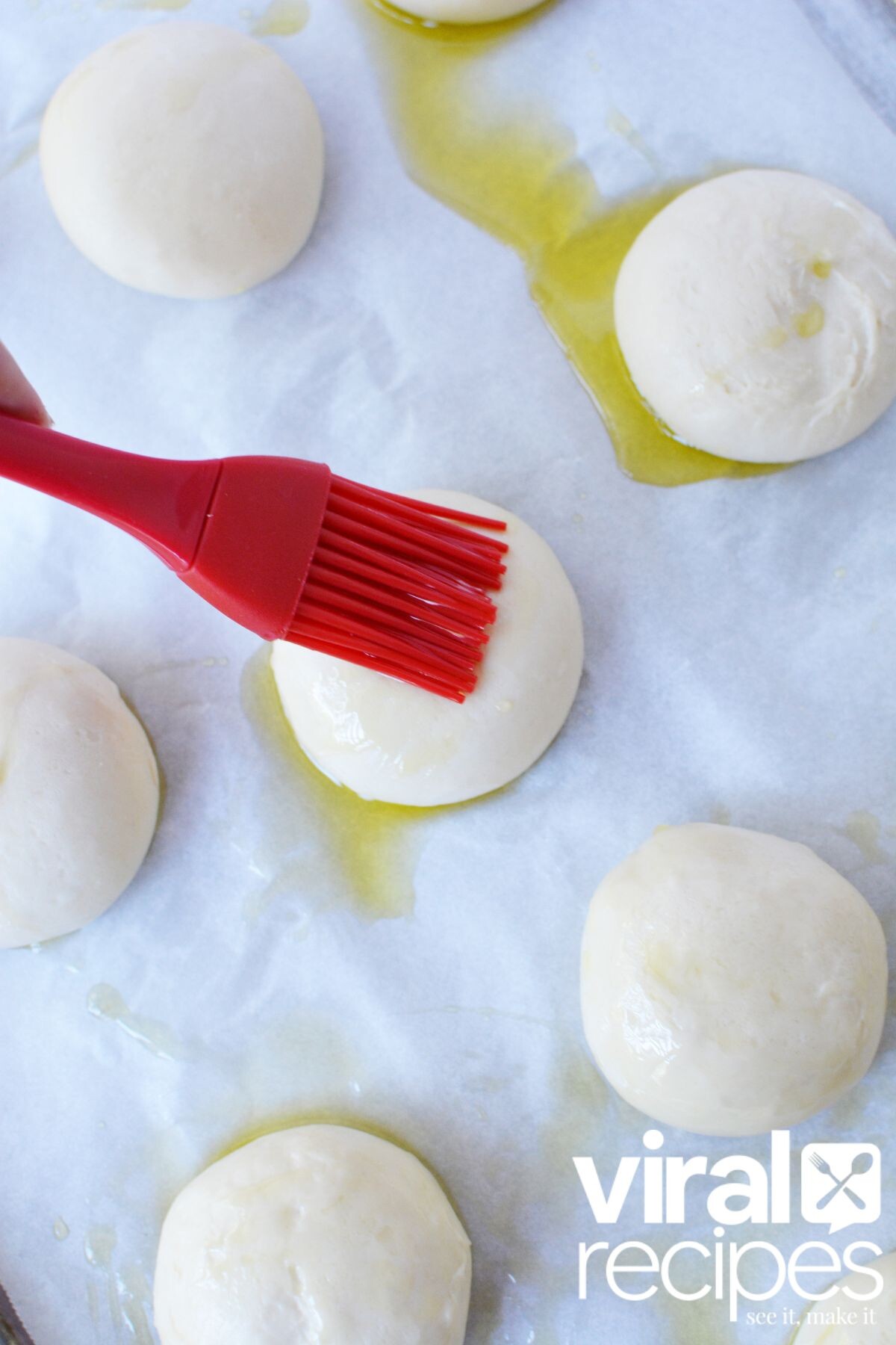 adding oil to a dinner roll.