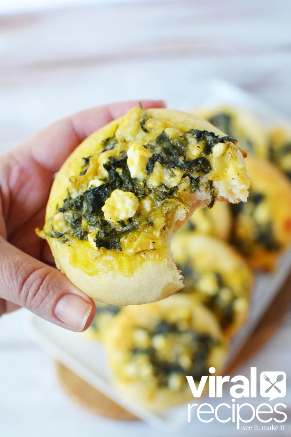 mini rolls with spinach and feta cheese bit into.