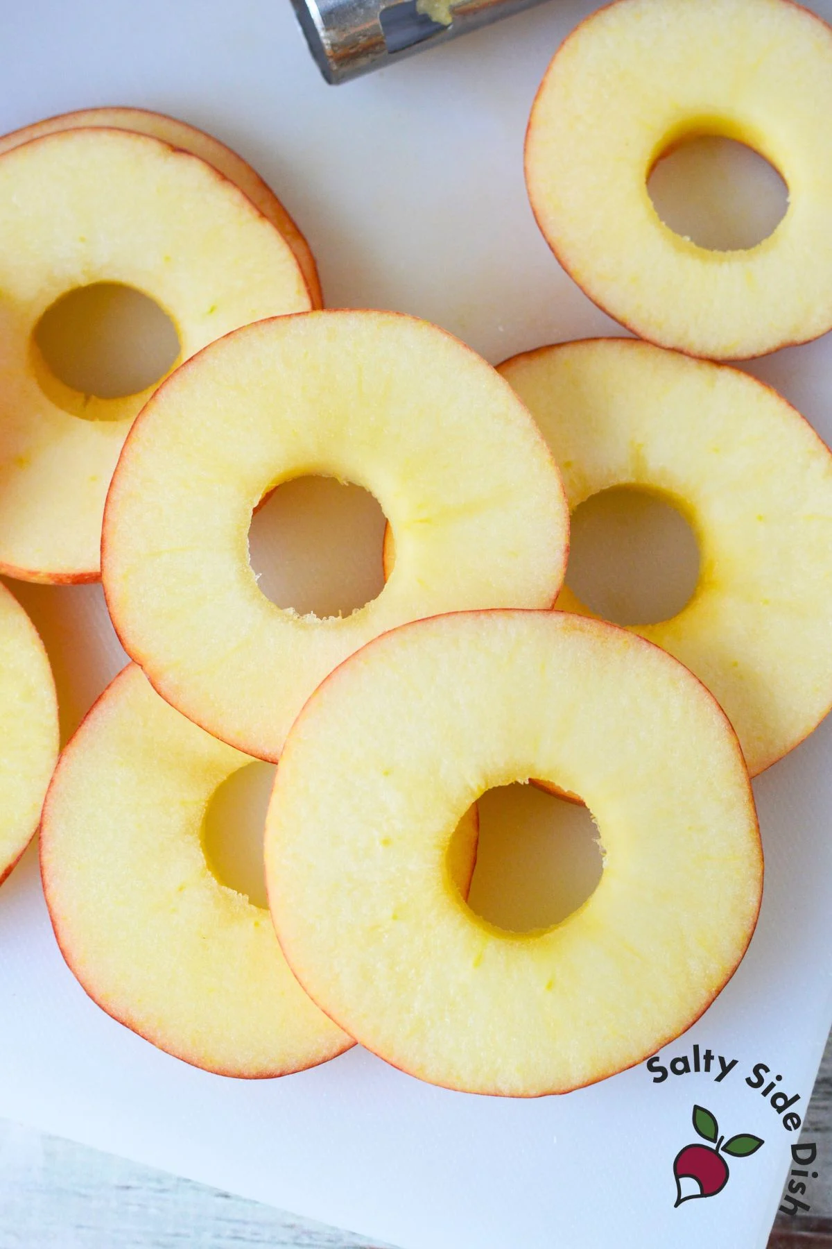 apples sliced and cored on a cutting board.