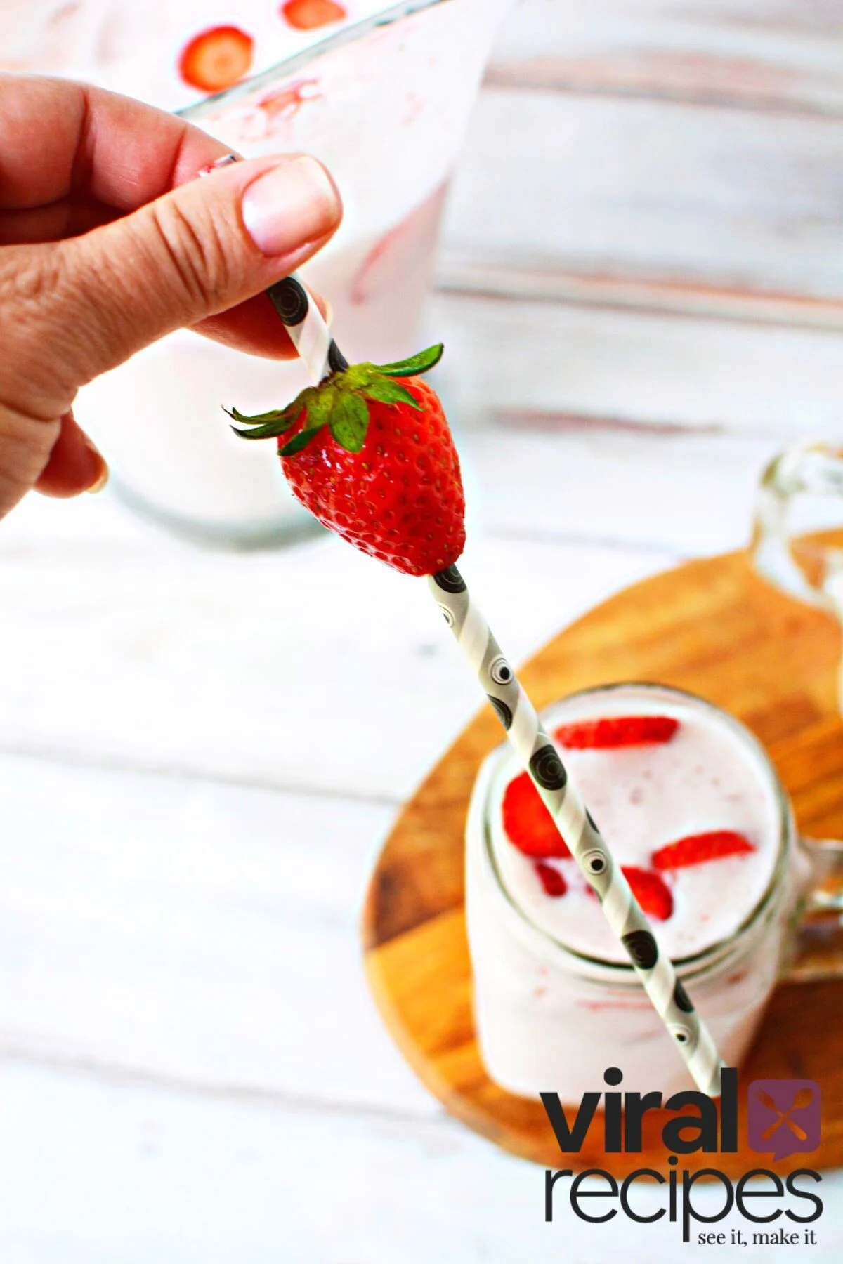 adding strawberry to a straw.