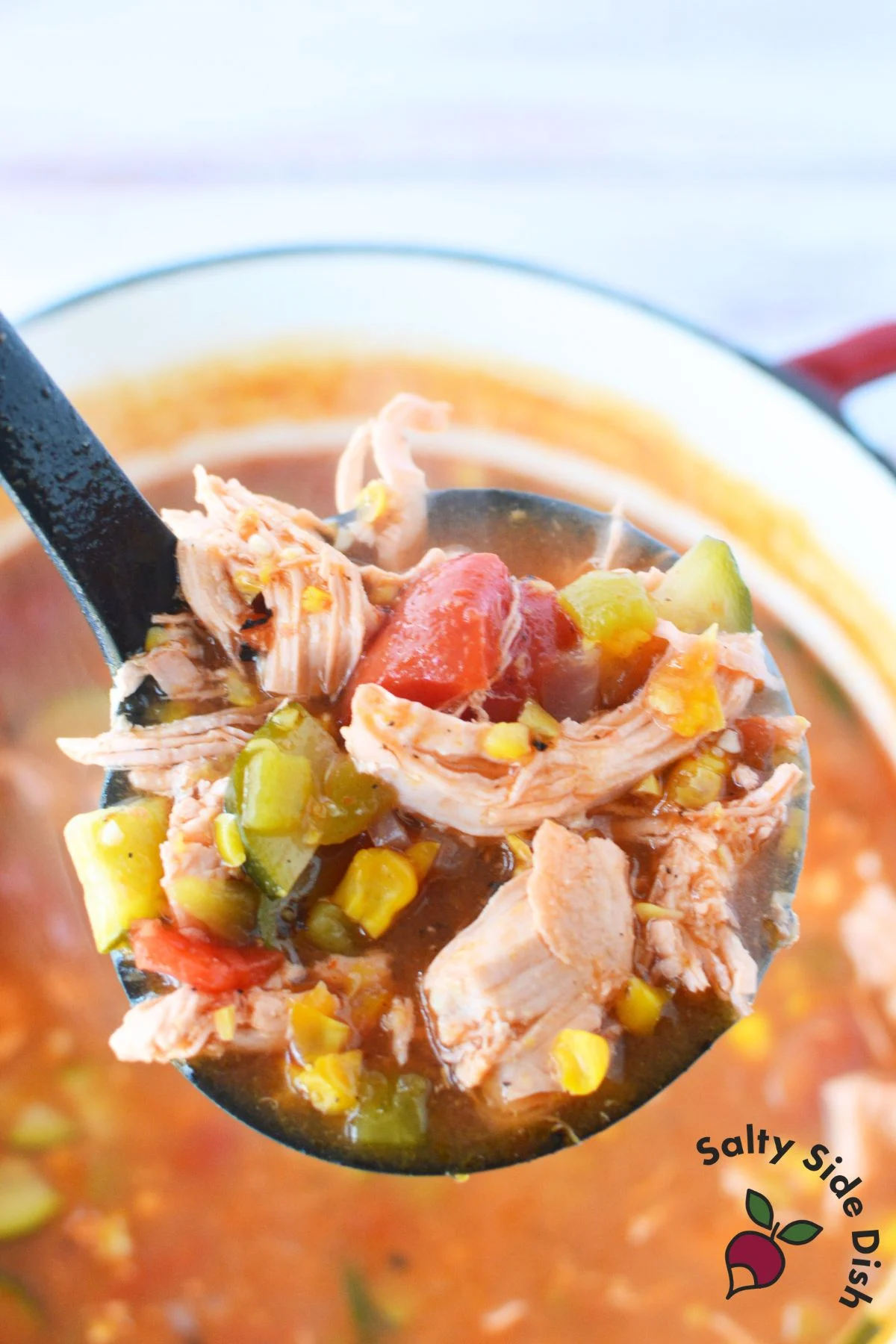 ladle with chicken, zucchini, taco flavoring, and corn.