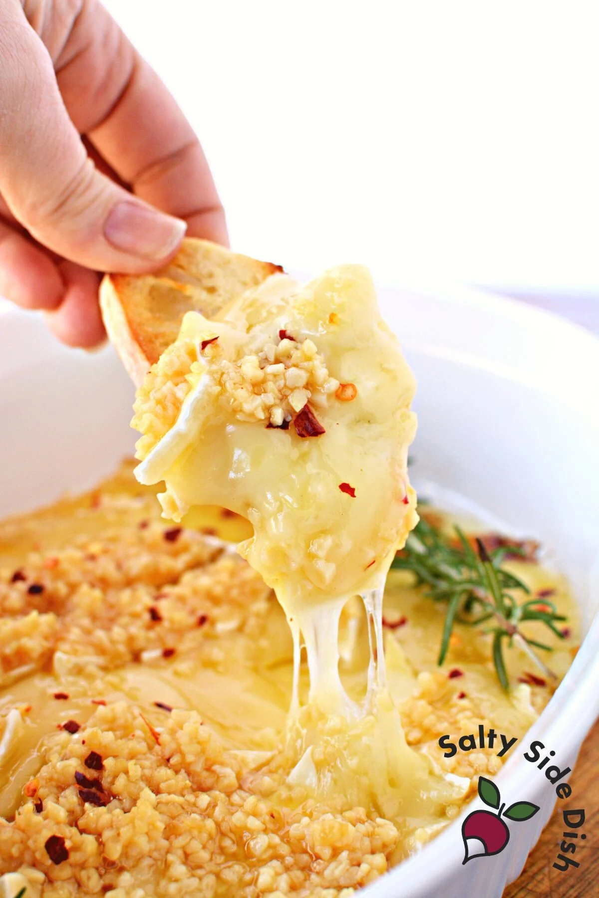 dip baked brie with a crusty piece of bread.