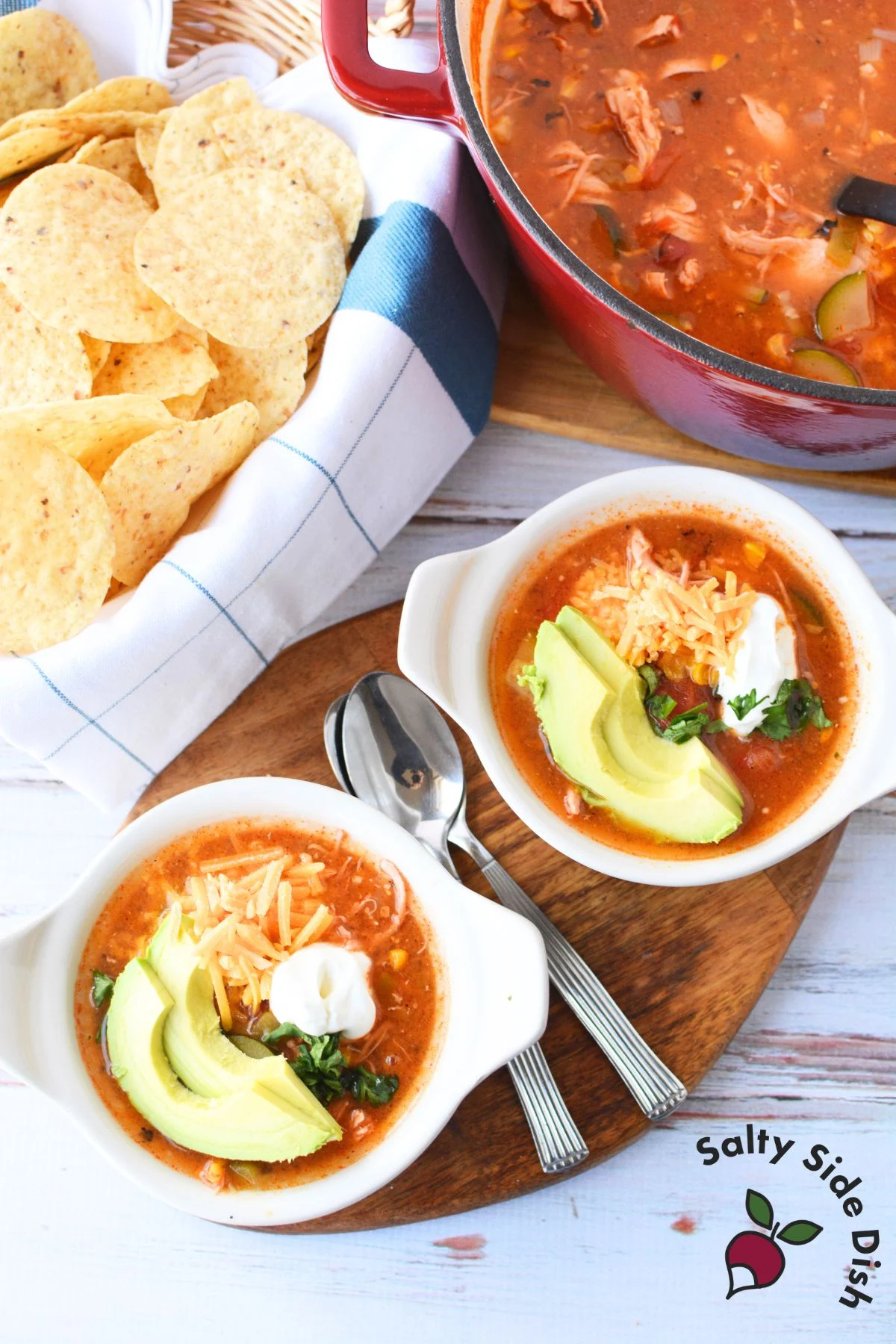 zucchini taco soup with avocado, cheese, and serving with tortillas.