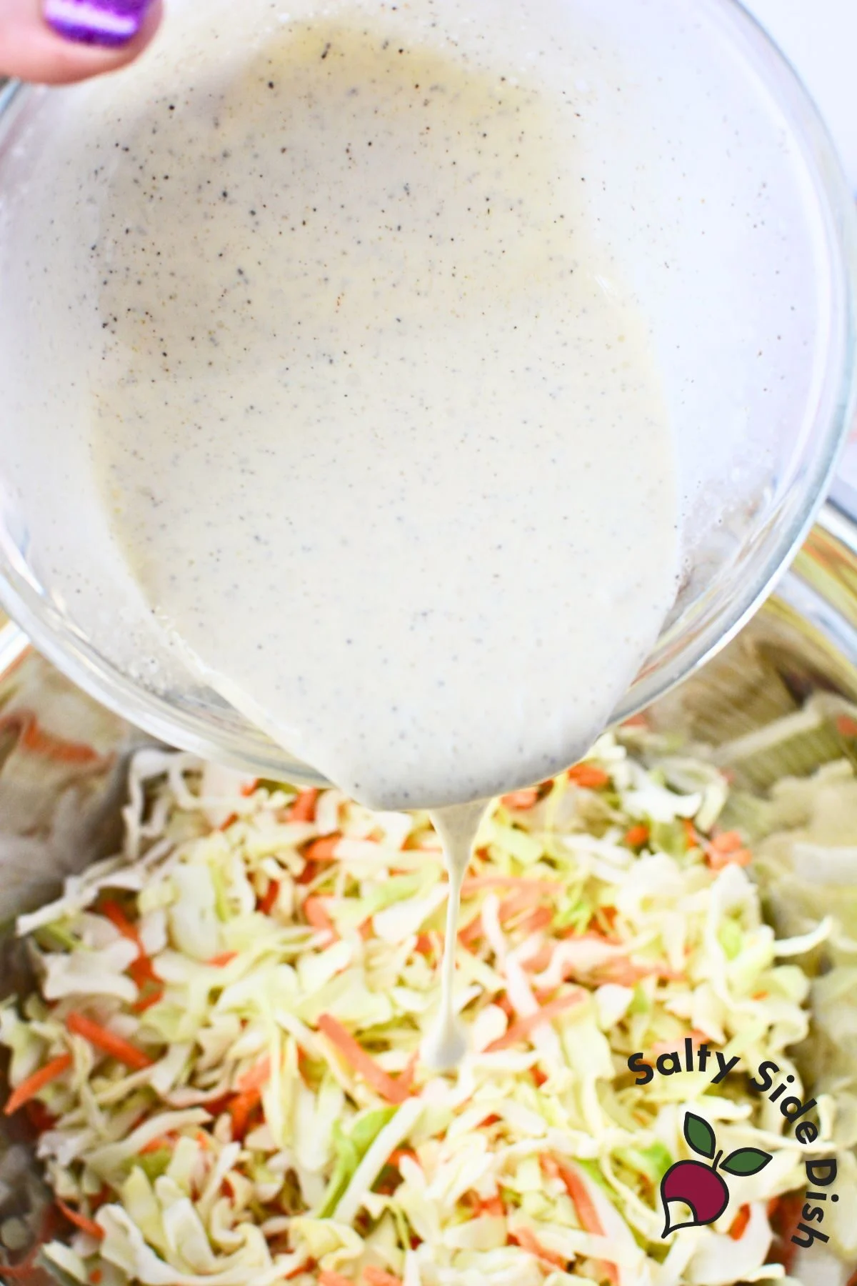 coleslaw dressing being poured onto veggies.