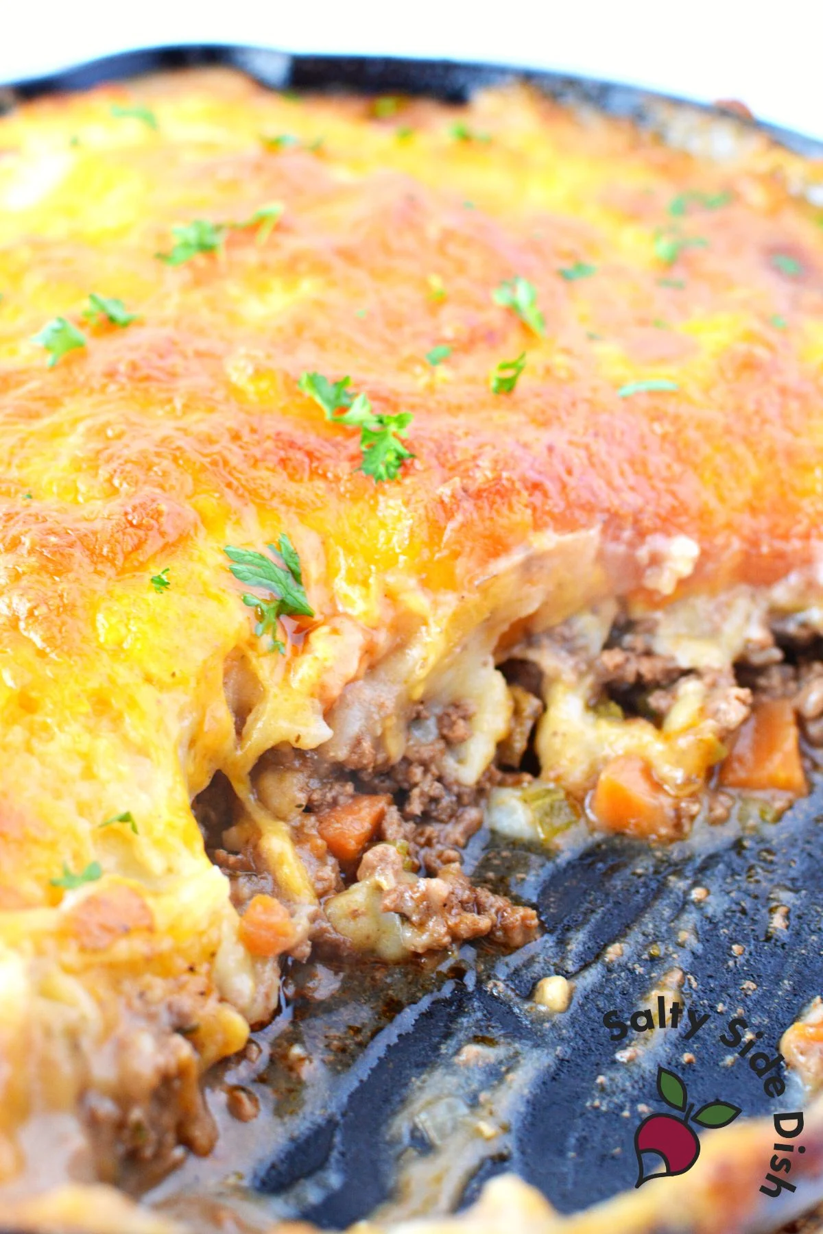 scoop of shepards pie in a cast iron pan.