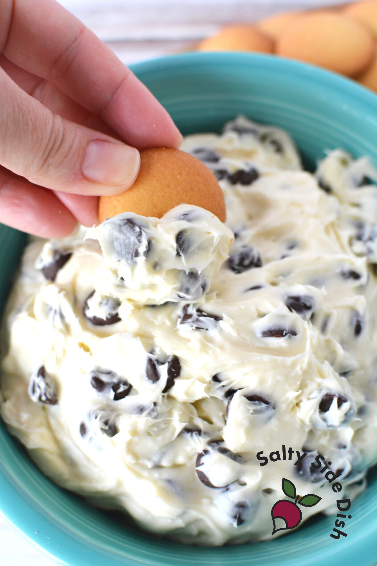 dipping a cookie into the perfect fall dip with chocolate chips.