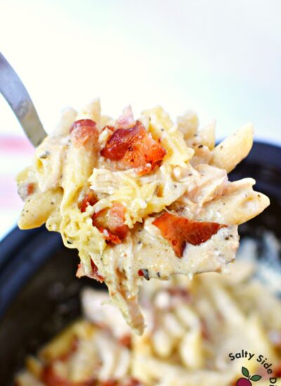 penne pasta and garlic chicken on a spoon.