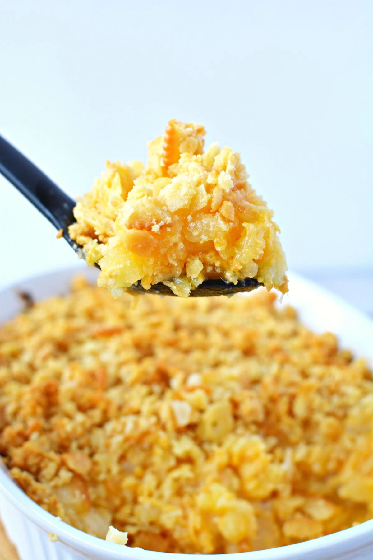 spoonful of sweet pineapple casserole with cracker topping.