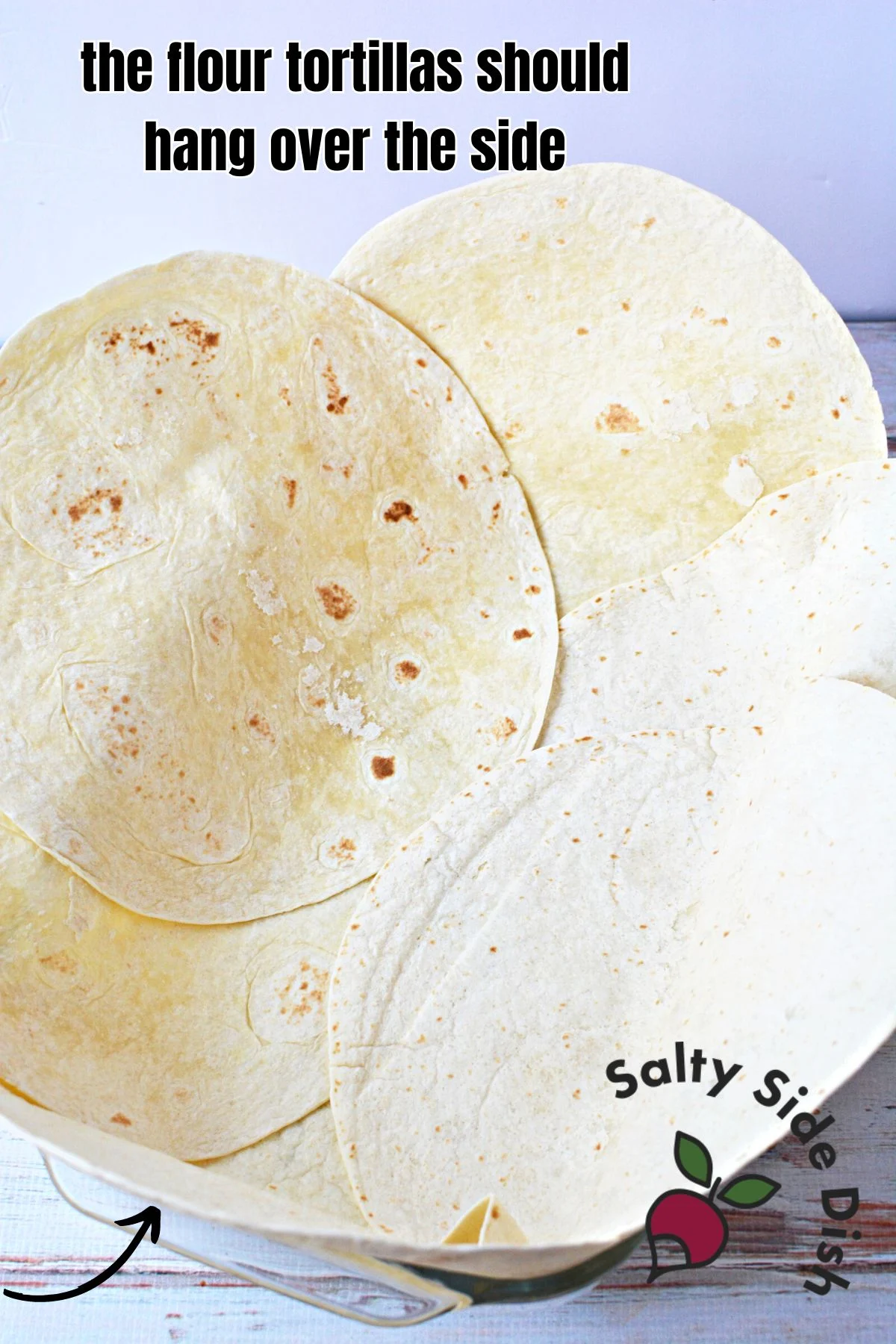 place overlapped extra large tortillas over side of oven safe baking dish.
