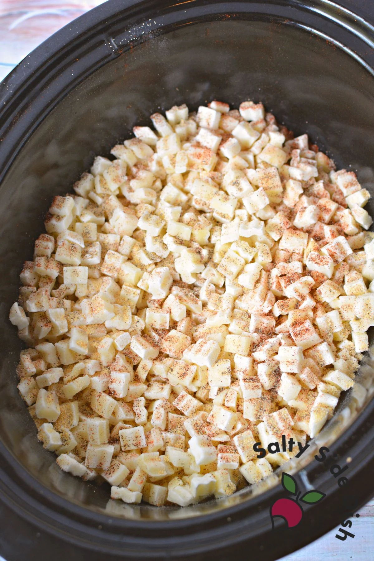 layered potatoes and seasoning in crockpot.