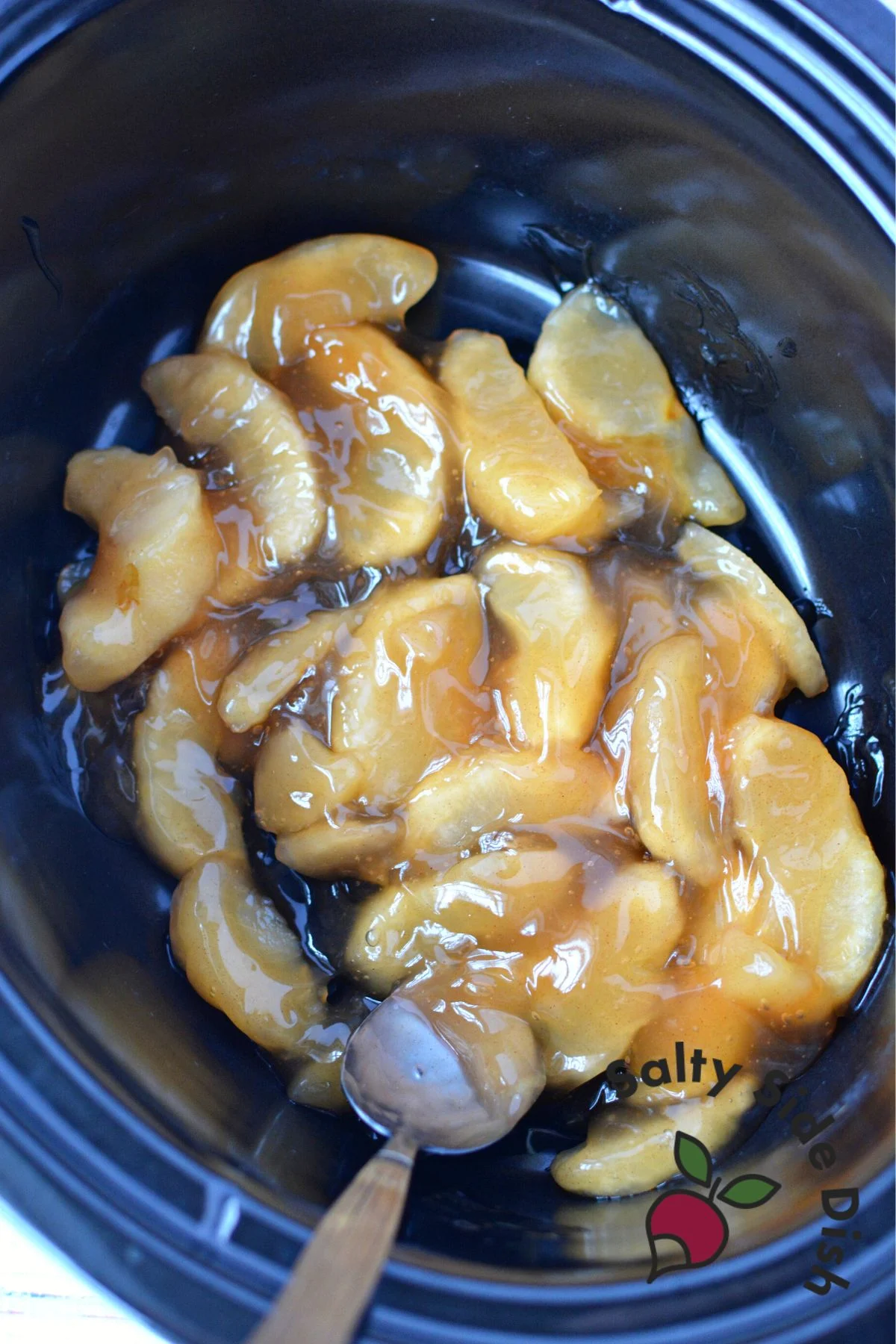 apple pie filling into the bottom of the black slow cooker.