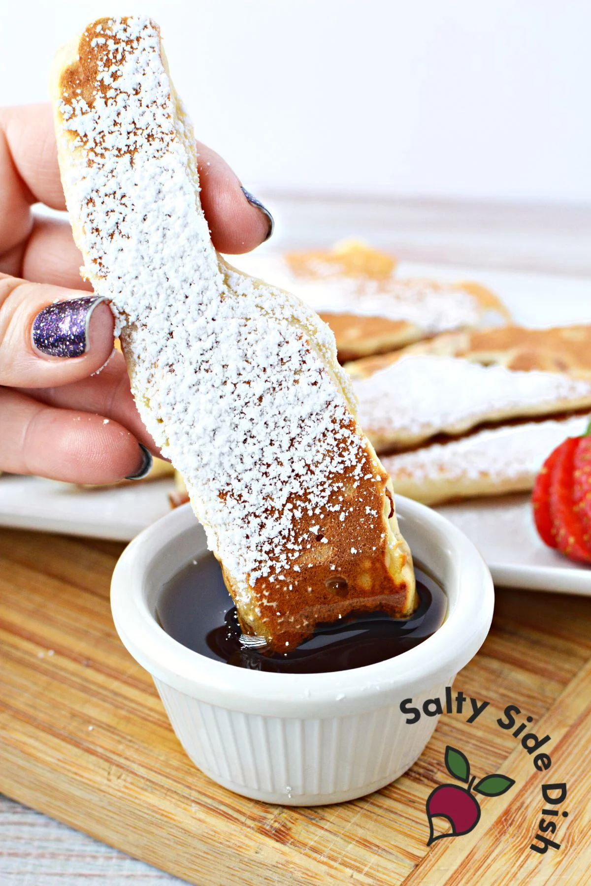 dipping pancake dipper into maple syrup.