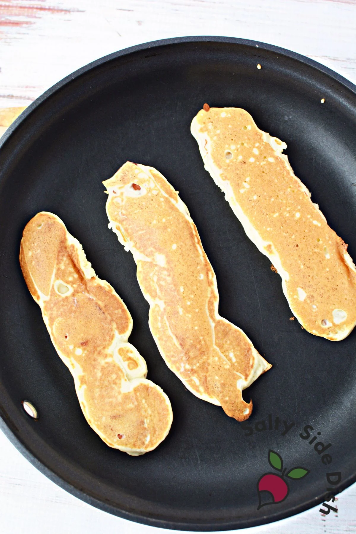 bacon pancakes in a skillet.