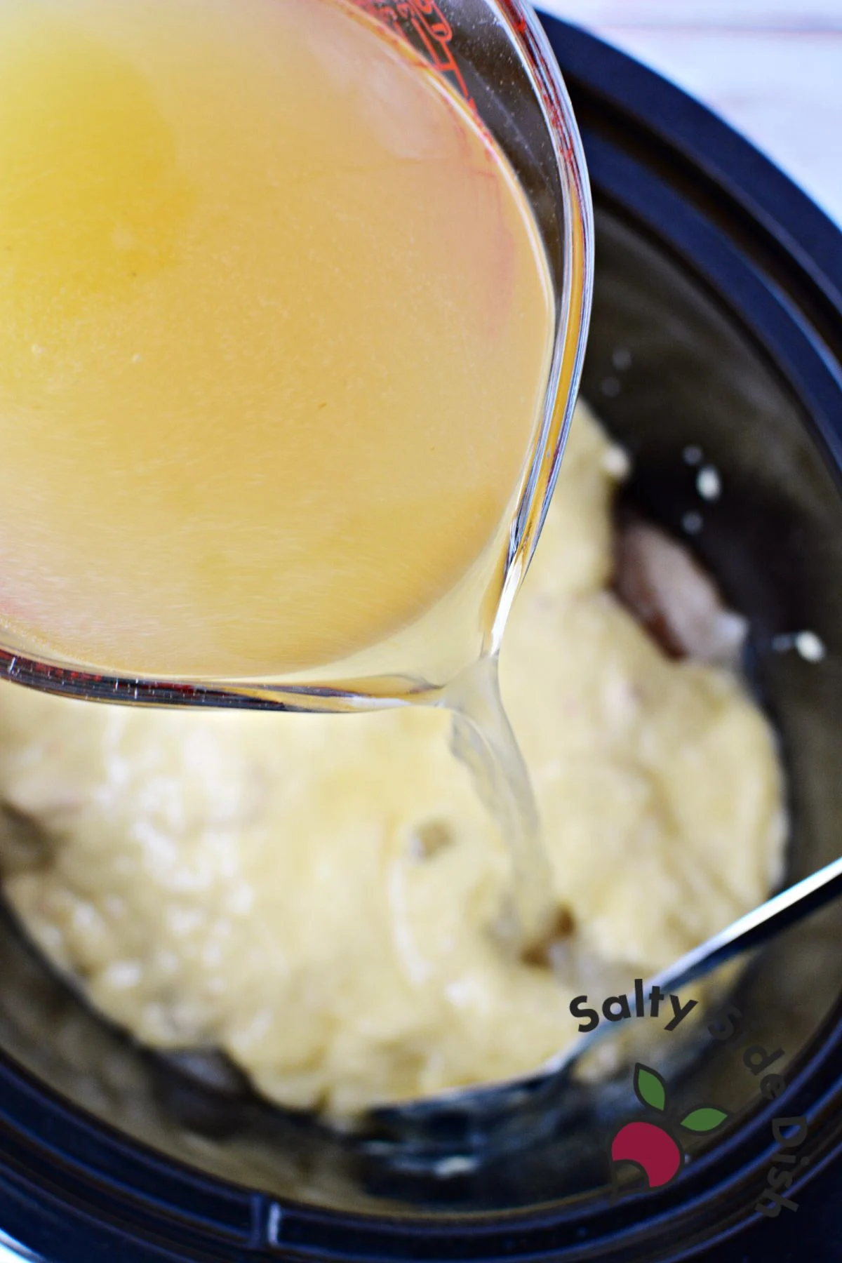 dumping chicken broth into slow cooker.
