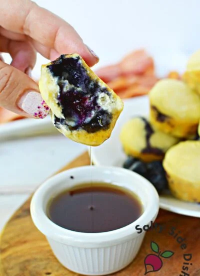 mini pancake being dipped into syrup.