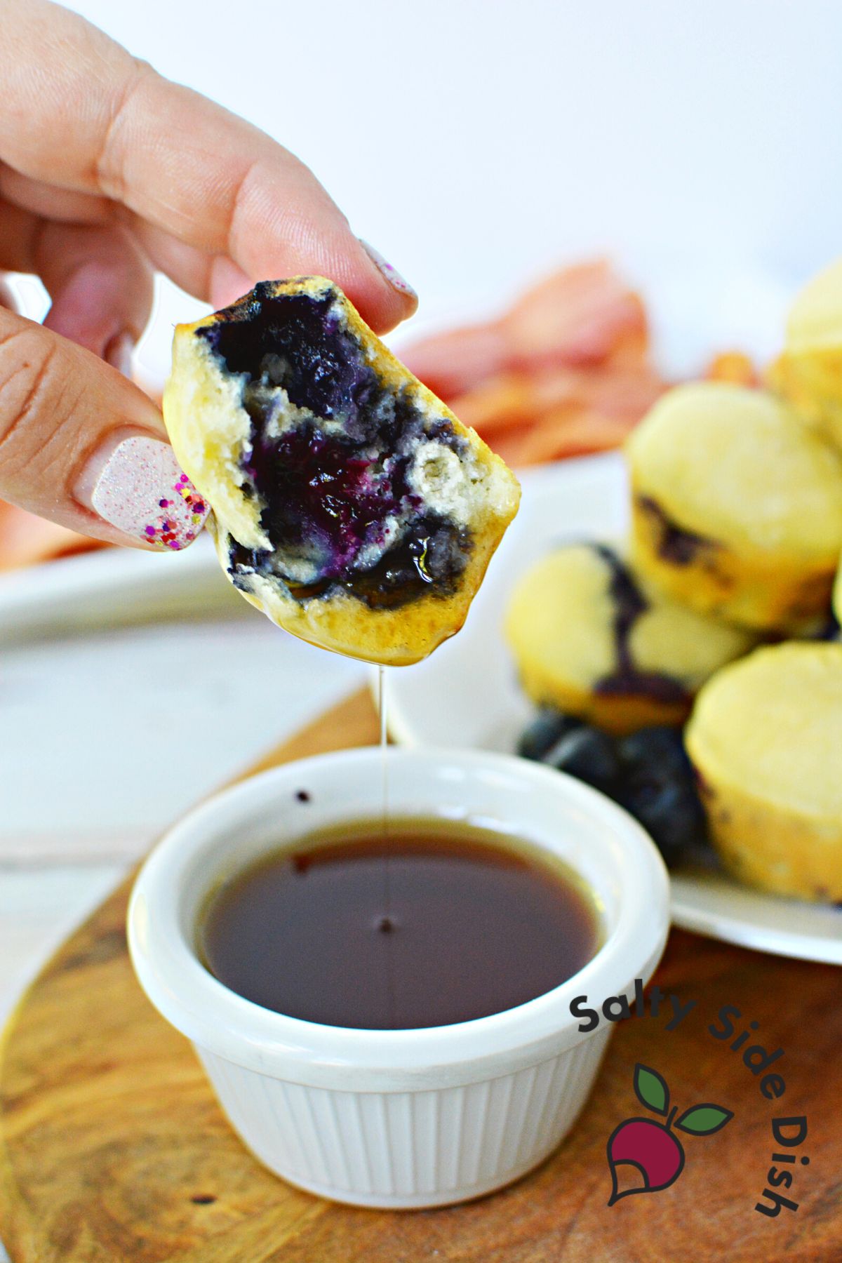 mini muffin being dipped into syrup.