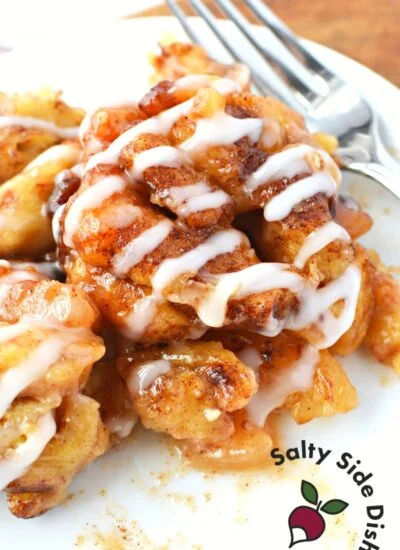 apple cinnamon cinnamon rolls on a white plate with a fork.