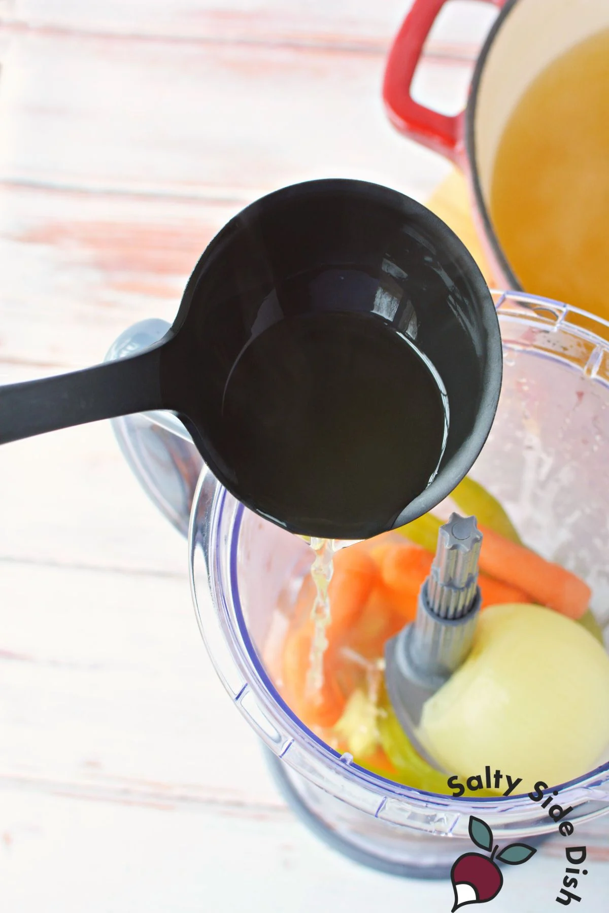 pouring broth into vegetable blender.