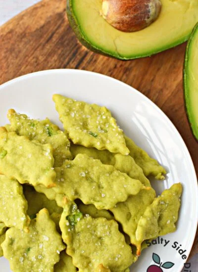 oven baked avocado crackers on a white plate.
