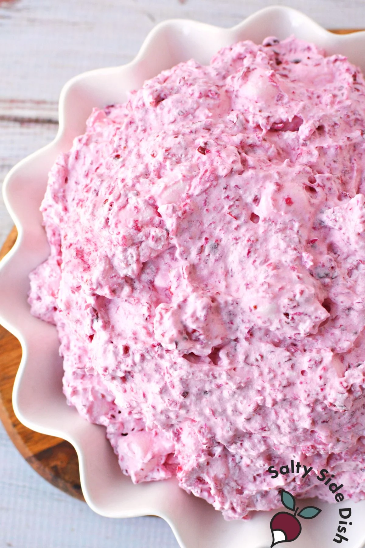 a bowl of cranberry fluff salad with marshmallows and cool whipped topping.