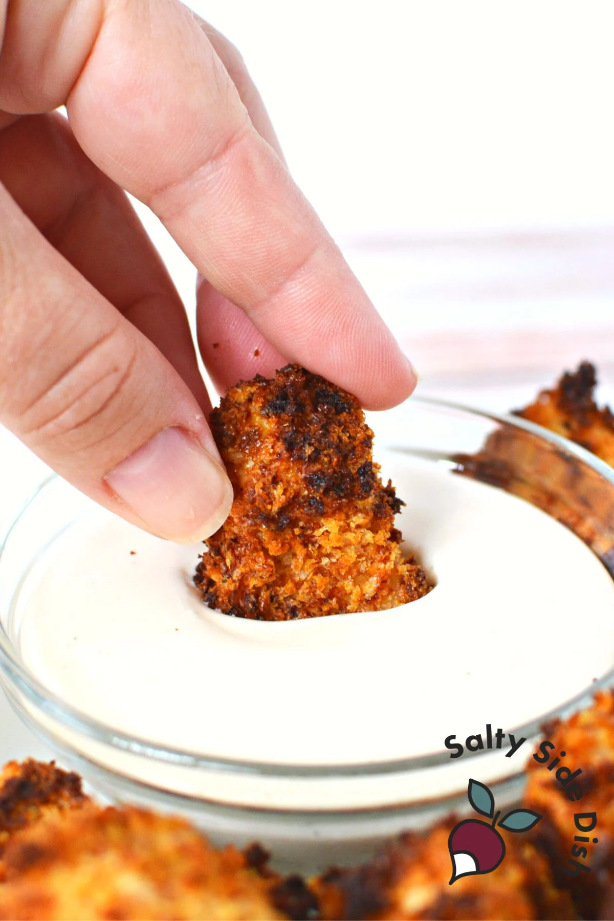 dipping chicken nugget into sauce.